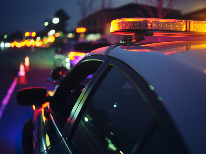 A police car stopping a vehicle at night. (Credit: Getty Creative)