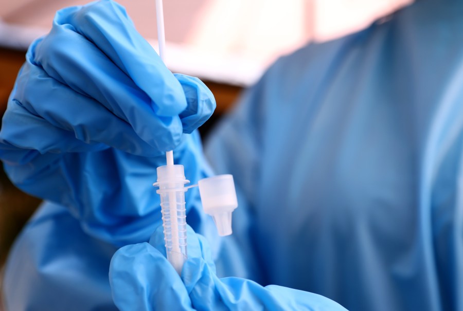 A registered nurse stirs a nasal swab in testing solution after administering a coronavirus on July 14, 2021 in Los Angeles, California. (Mario Tama/Getty Images)