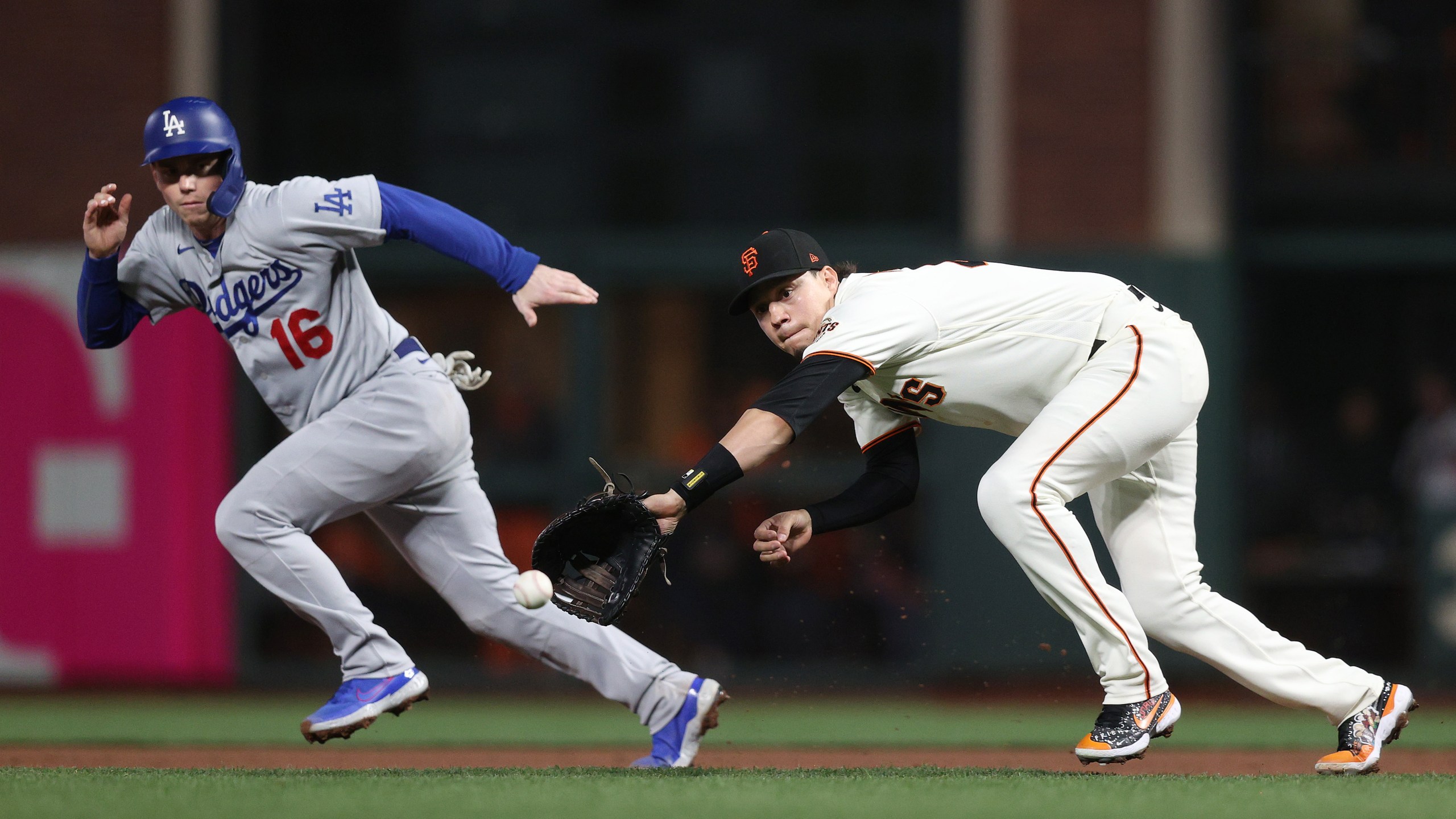 Wilmer Flores of the San Francisco Giants makes a diving catch and throws out Will Smith of the Los Angeles Dodgers on a fielder's choice during the fifth inning of Game 1 of the National League Division Series at Oracle Park in San Francisco on Oct. 8, 2021. (Ezra Shaw / Getty Images)