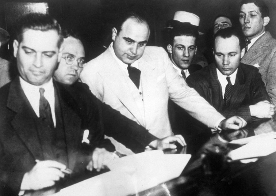 Al Capone (1899 - 1947) signing Uncle Sam's $50,000 bail bond in the Federal Building, Chicago. (Topical Press Agency/Getty Images)