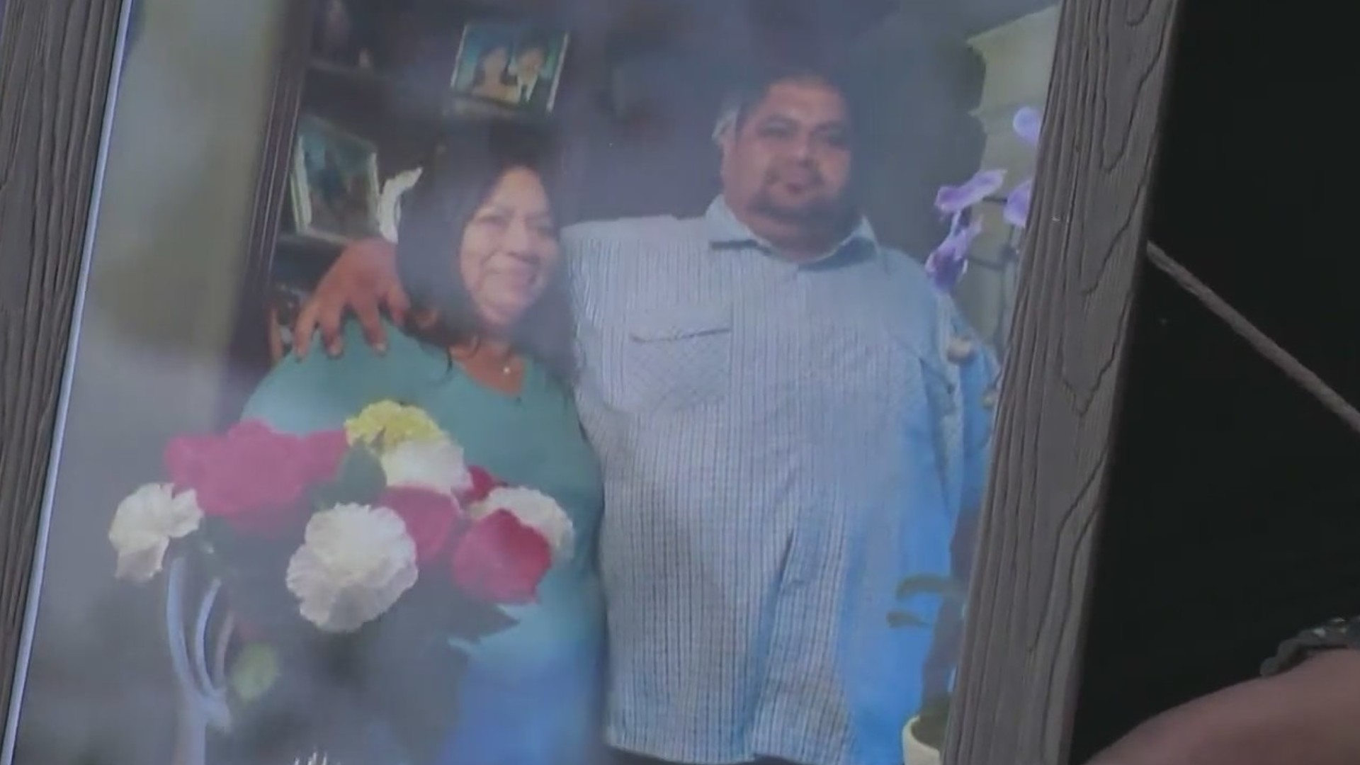 Relatives hold up a photo of Melguin Lopez on Oct. 11, 2021. (KTLA)