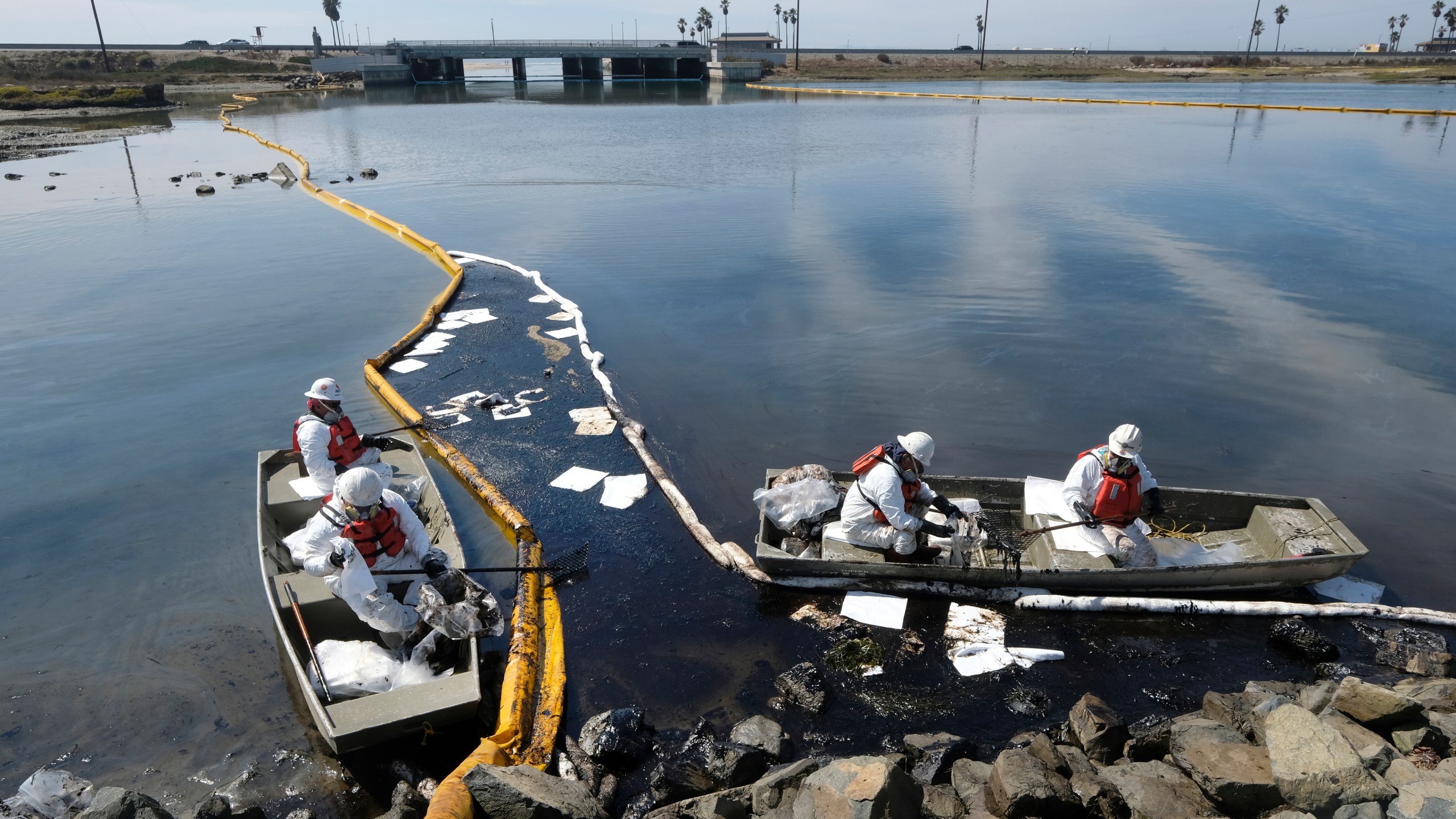 Cleanup contractors deploy skimmers and floating barriers known as booms to try to stop further oil crude incursion into the Wetlands Talbert Marsh in Huntington Beach, Calif., Sunday., Oct. 3, 2021. One of the largest oil spills in recent Southern California history fouled popular beaches and killed wildlife while crews scrambled Sunday to contain the crude before it spread further into protected wetlands. (AP Photo/Ringo H.W. Chiu)