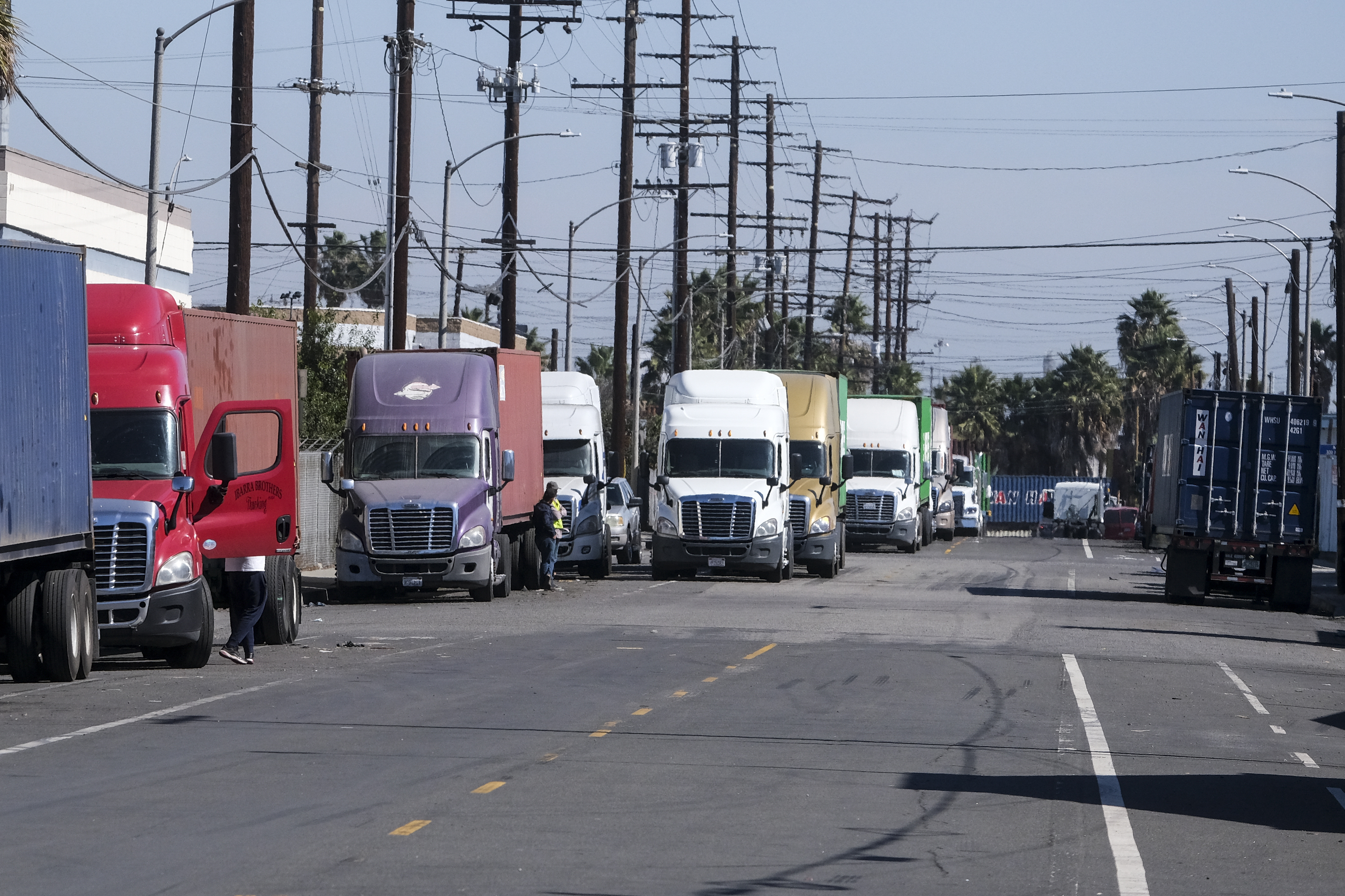 Parked cargo container trucks are seen in a street, Wednesday, Oct. 20, 2021 in Wilmington, Calif. California Gov. Gavin Newsom on Wednesday issued an order that aims to ease bottlenecks at the ports of Los Angeles and Long Beach that have spilled over into neighborhoods where cargo trucks are clogging residential streets. (AP Photo/Ringo H.W. Chiu)