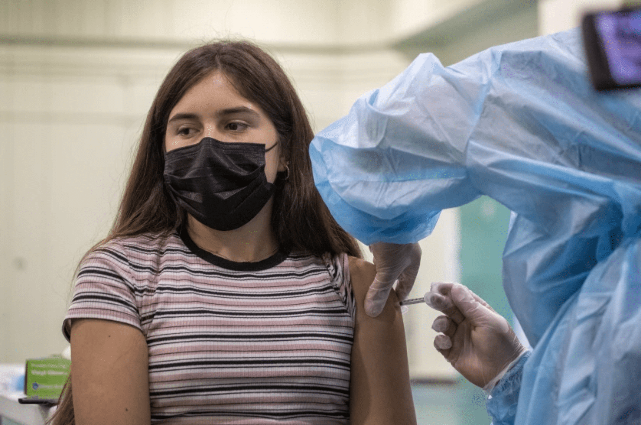 A nurse administers a COVID-19 vaccine to Gizelle Carrillo, 14, in August at Eagle Rock Junior/Senior High School. The L.A. and San Diego school districts face lawsuits challenging their mandates for students to be vaccinated.(Allen J. Schaben / Los Angeles Times)