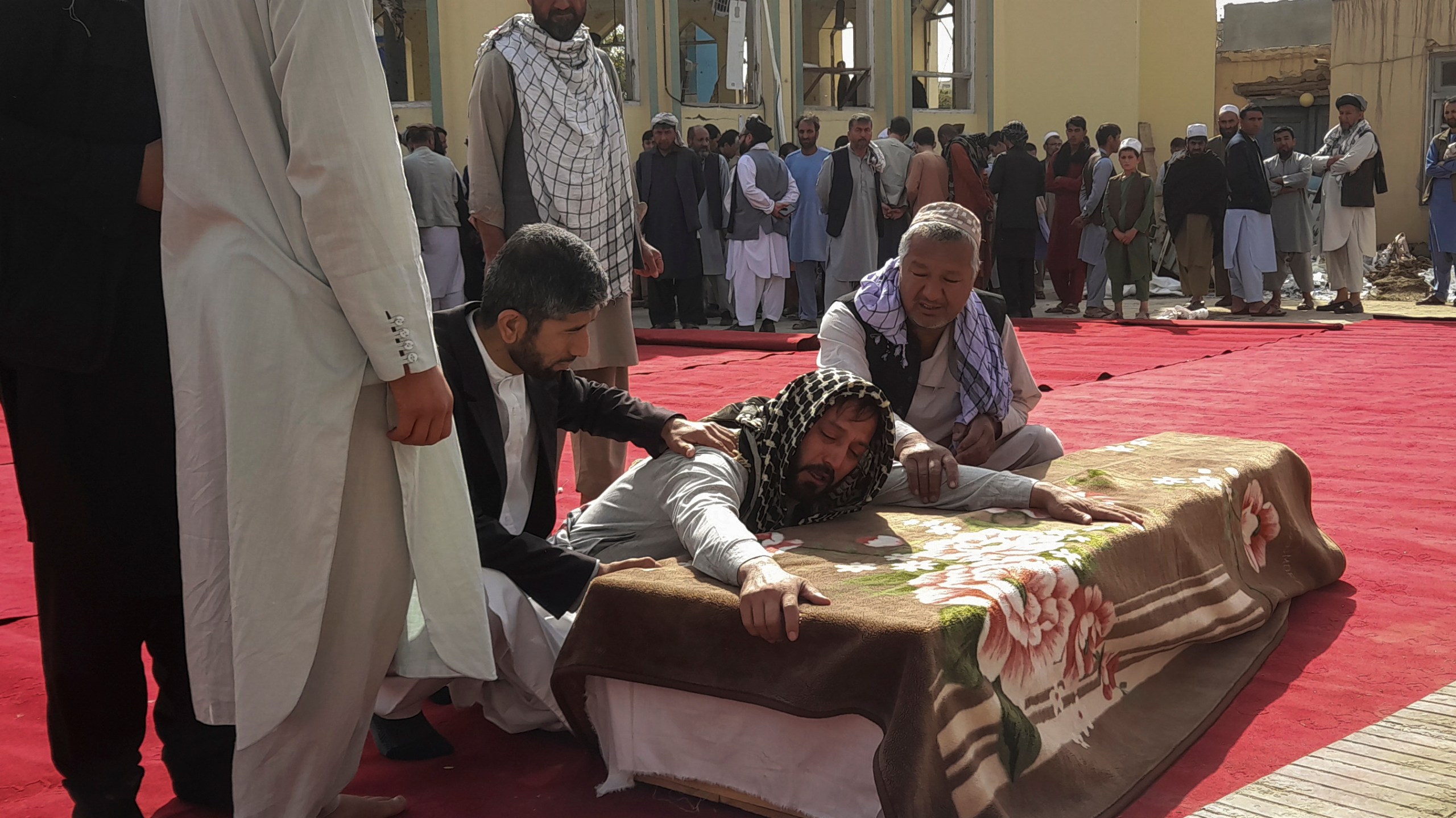 Relatives and residents attend a funeral ceremony for victims of a suicide attack at the Gozar-e-Sayed Abad Mosque in Kunduz, northern Afghanistan, Saturday, Oct. 9, 2021. The mosque was packed with Shiite Muslim worshippers when an Islamic State suicide bomber attacked during Friday prayers, killing dozens in the latest security challenge to the Taliban as they transition from insurgency to governance. (AP Photo/Abdullah Sahil)