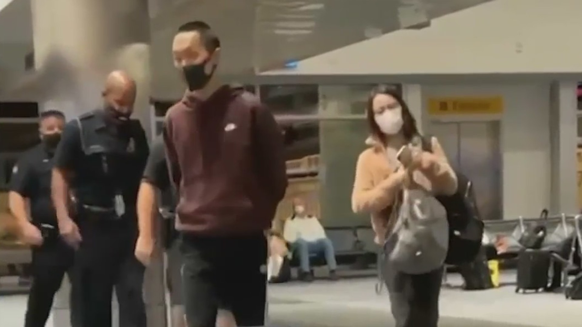 A suspect is seen in handcuffs after a flight attendant was punched on an American Airlines flight. (OC Hawk)