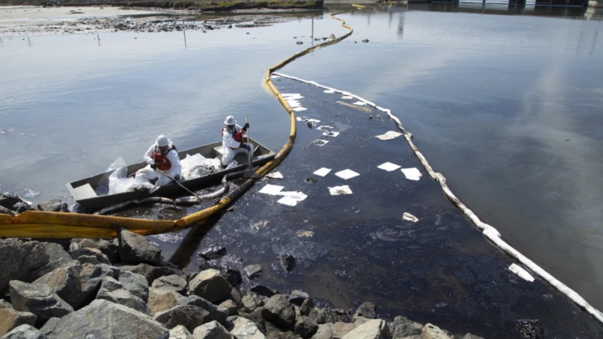 Workers with Patriot Environmental Services on Sunday clean up oil that flowed into the Talbert Marsh near Huntington State Beach.(Myung J. Chun / Los Angeles Times)