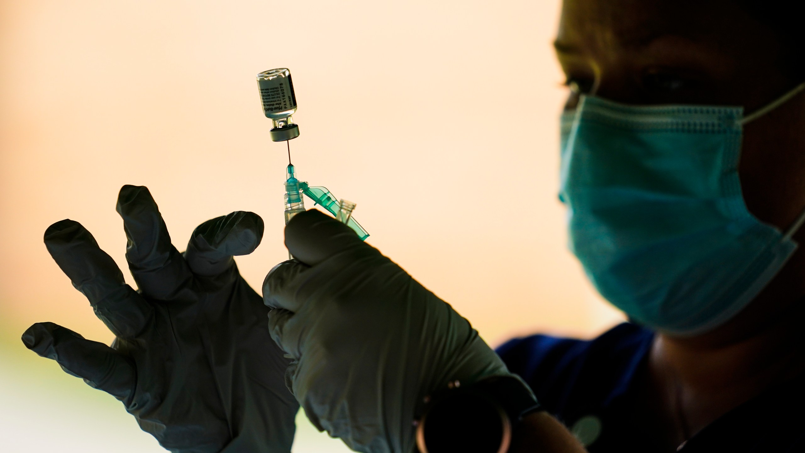 In this Sept. 14, 2021, file photo, a syringe is prepared with the Pfizer COVID-19 vaccine at a clinic at the Reading Area Community College in Reading, Pa. Millions of U.S. workers now have a Jan. 4 deadline to get a COVID vaccine. The federal government on Thursday, Nov. 4, 2021 announced new vaccine requirements for workers at companies with more than 100 employees as well as workers at health care facilities that treat Medicare and Medicaid patients.. (AP Photo/Matt Rourke, File)