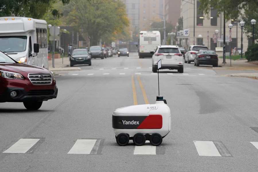 A food delivery robot crosses a street in Ann Arbor, Mich. on Thursday, Oct. 7, 2021. (AP Photo/Carlos Osorio)