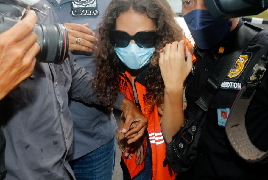 Heather Mack of Chicago, Ill., center, escorted by immigration officers to Immigration detention center in Jimbaran, Bali, Indonesia on Friday, Oct. 29, 2021. Indonesian authorities on Tuesday, Nov. 2, 2021, announced that Mack, an American woman convicted of helping to kill her mother on Indonesia's tourist island of Bali in 2014, is preparing to leave island to be deported to the United States after serving seven years of a 10-year sentence. (AP Photo/Firdia Lisnawati, File)