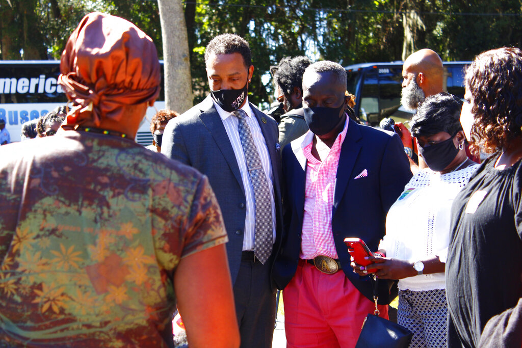 Marcus Arbery stands between a representative of the Transformative Justice Coalition and a community member October 2021 overlooking the stretch of pavement where his son, Ahmaud Arbery, was killed. (Asia Burns/The Atlanta Journal-Constitution via AP)