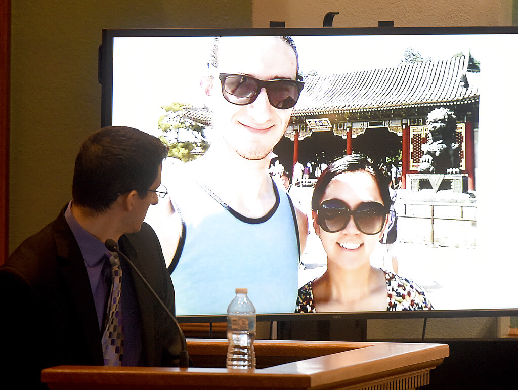 Defendant Joseph Elledge looks at a photo of himself and his late wife Mengqi Ji, when they took a trip to China to visit her relatives during questioning by defense attorney Scott Rosenblum, on Tuesday, Nov. 9, 2021, in Columbia, Missouri. (Don Shrubshell/Columbia Daily Tribune via AP, Pool)