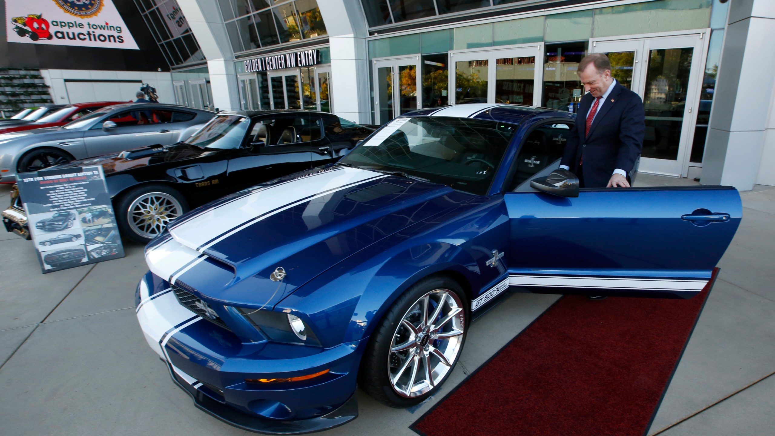 In this Oct. 23, 2019, file photo, McGregor Scott, who was then the U.S. Attorney for the Eastern District of California, looks over a 2007 Ford Shelby GT500 displayed in Sacramento, Calif., that was among the vehicles seized by the federal government to be auctioned off. The cars belonged to Jeff and Paulette Carpoff, owners of a San Francisco Bay Area solar energy company that pleaded guilty for participating in what federal prosecutors called a massive Ponzi scheme that defrauded investors of $1 billion. (AP Photo/Rich Pedroncelli, File)