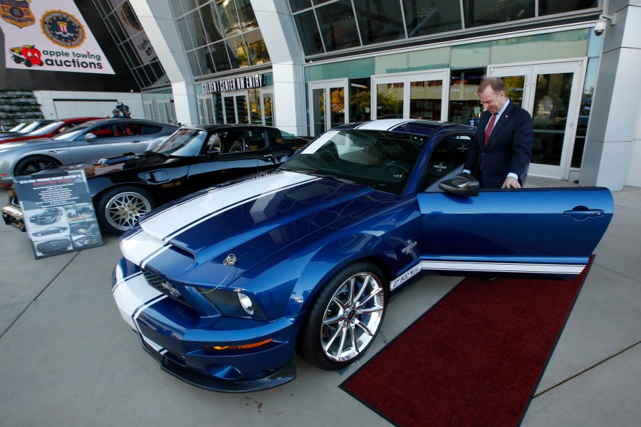 In this Oct. 23, 2019, file photo, McGregor Scott, who was then the U.S. Attorney for the Eastern District of California, looks over a 2007 Ford Shelby GT500 displayed in Sacramento, Calif., that was among the vehicles seized by the federal government to be auctioned off. The cars belonged to Jeff and Paulette Carpoff, owners of a San Francisco Bay Area solar energy company that pleaded guilty for participating in what federal prosecutors called a massive Ponzi scheme that defrauded investors of $1 billion. (AP Photo/Rich Pedroncelli, File)