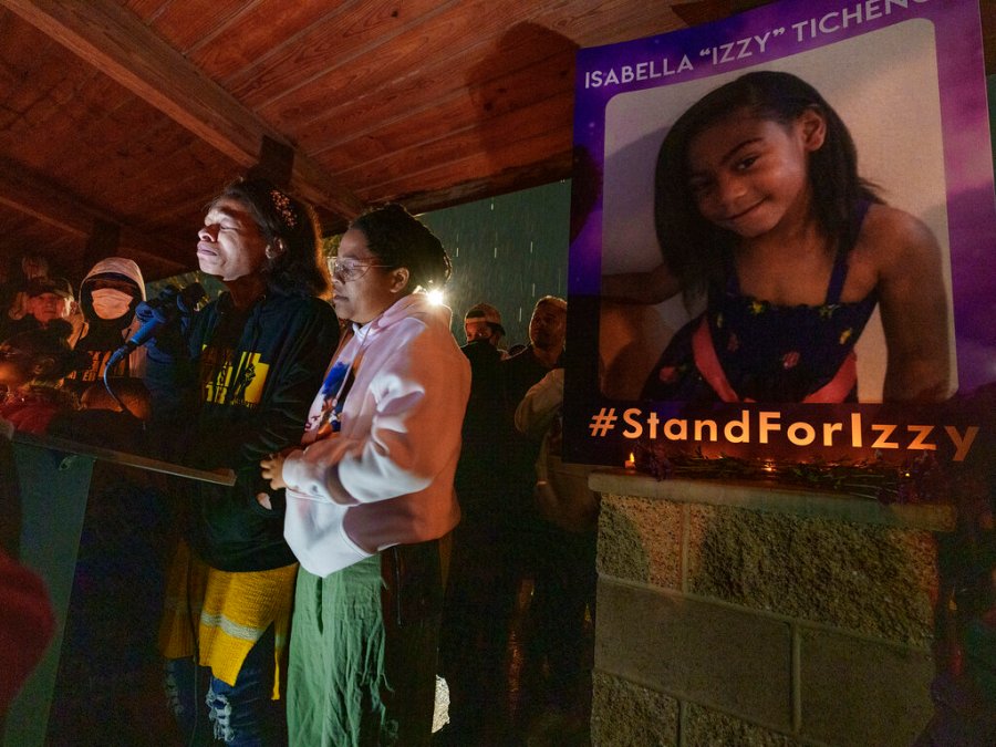 Brittany Tichenor- Cox, center, joined by her sister Jasmine Rhodes, right, speaks about her daughter Izzy Tichenor, as hundreds joined the Tichenor family in mourning the death of 10-year-old Isabella "Izzy" Tichenor during a vigil at Foxboro Hollow Park in North Salt Lake, Utah, on Tuesday, Nov. 9, 2021. (Leah Hogsten/The Salt Lake Tribune via AP)