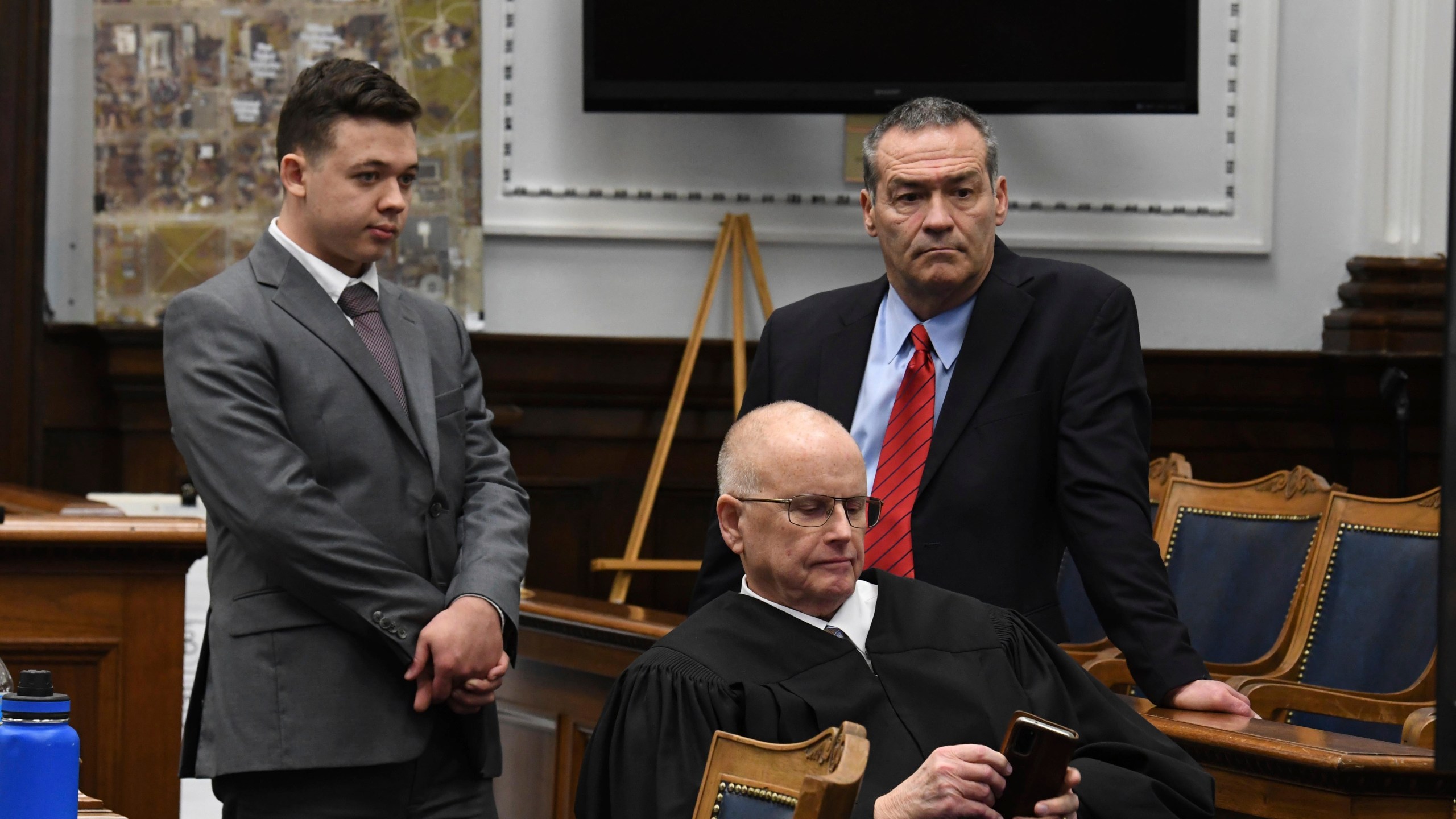 Kyle Rittenhouse and defense attorney Mark Richards stand as Judge Bruce Schroeder makes a personal call during Rittenhouse's trial at the Kenosha County Courthouse in Kenosha, Wis., on Nov. 12, 2021. Rittenhouse is accused of killing two people and wounding a third during a protest over police brutality in Kenosha, last year. (Mark Hertzberg /Pool Photo via AP)