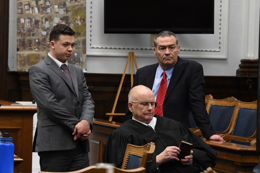 Kyle Rittenhouse and defense attorney Mark Richards stand as Judge Bruce Schroeder makes a personal call during Rittenhouse's trial at the Kenosha County Courthouse in Kenosha, Wis., on Nov. 12, 2021. Rittenhouse is accused of killing two people and wounding a third during a protest over police brutality in Kenosha, last year. (Mark Hertzberg /Pool Photo via AP)