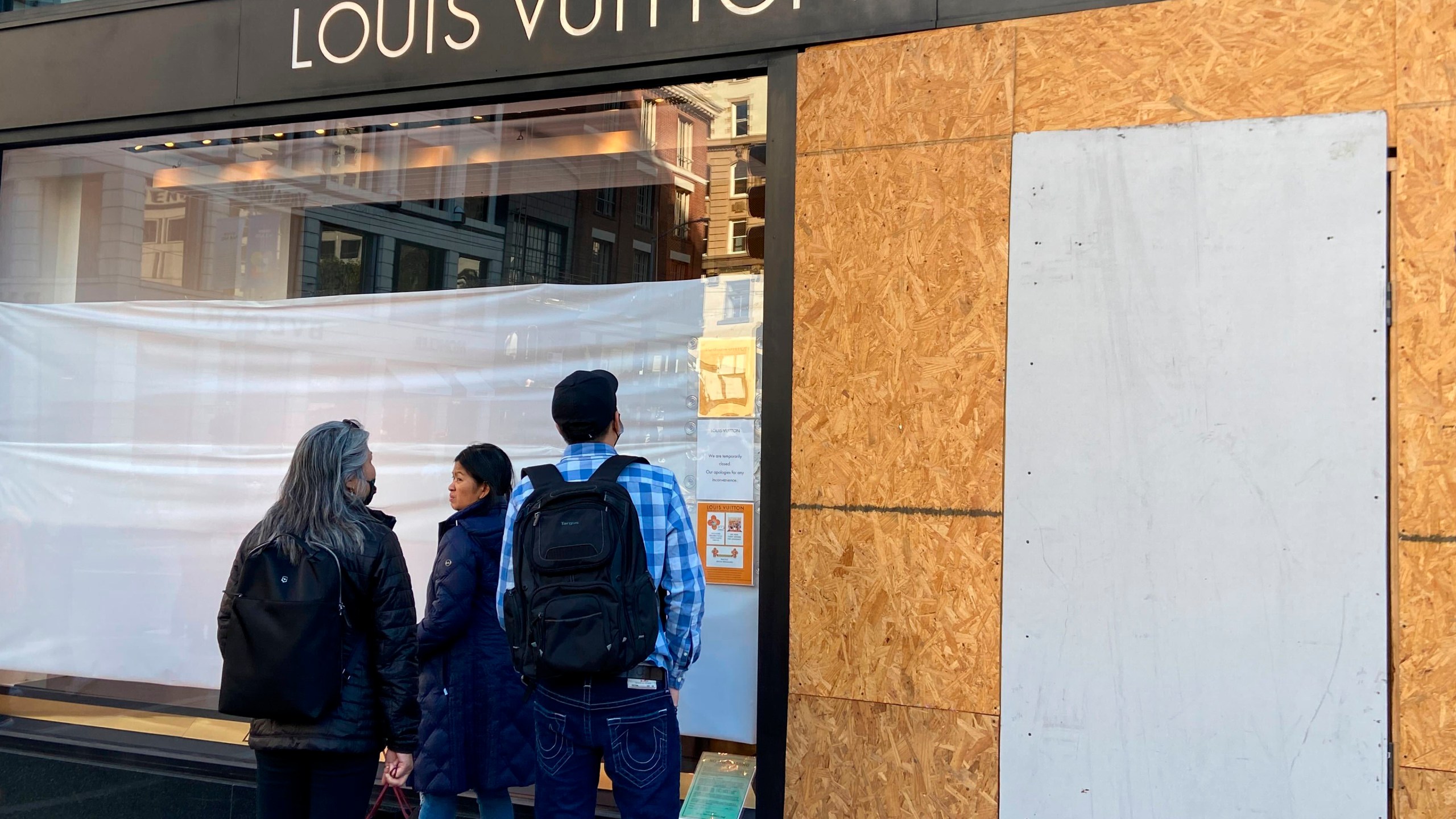 Union Square visitors look at damage to the Louis Vuitton store on Sunday, Nov. 21, 2021, after looters ransacked businesses late Saturday night in San Francisco. (Danielle Echeverria/San Francisco Chronicle via AP)