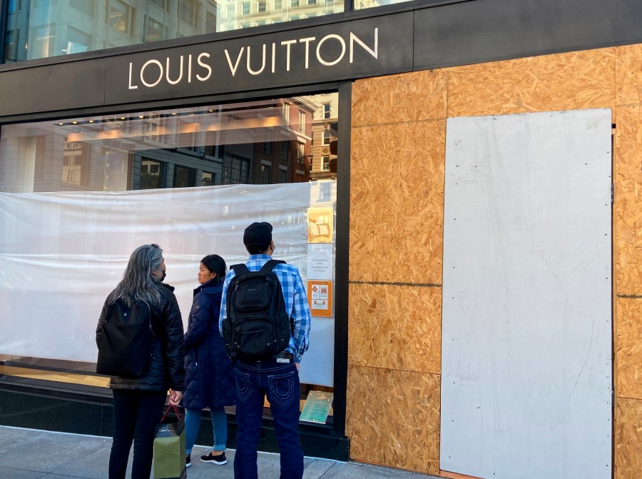 Union Square visitors look at damage to the Louis Vuitton store on Sunday, Nov. 21, 2021, after looters ransacked businesses late Saturday night in San Francisco. (Danielle Echeverria/San Francisco Chronicle via AP)