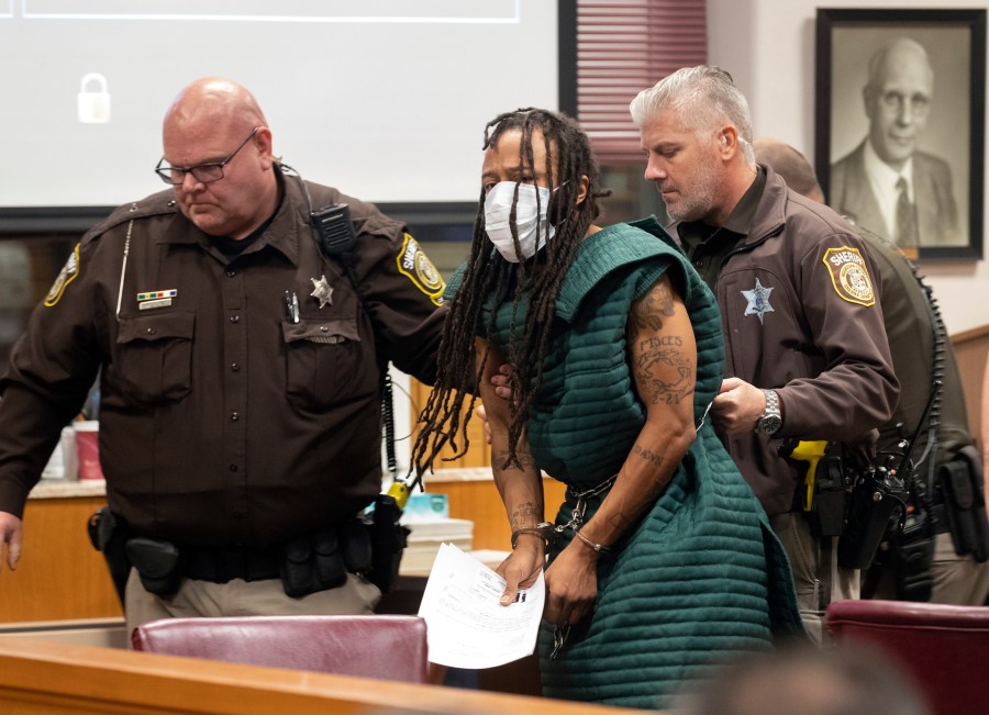 Darrell Brooks, center, is escorted out of the courtroom after making his initial appearance on Nov. 23, 2021, in Waukesha County Court in Waukesha, Wis. Prosecutors in Wisconsin have charged Brooks with intentional homicide in the deaths of at least five people who were killed when an SUV was driven into a Christmas parade. (Mark Hoffman/Milwaukee Journal-Sentinel via AP, Pool)