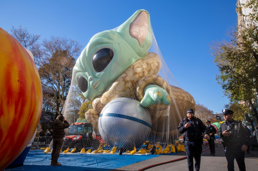 Police walk by an inflated helium balloon of Grogu, also known as Baby Yoda, from the Star Wars show The Mandalorian, Wednesday, Nov. 24, 2021, in New York, as the balloon is readied for the Macy's Thanksgiving Day Parade on Thursday. (AP Photo/Ted Shaffrey)