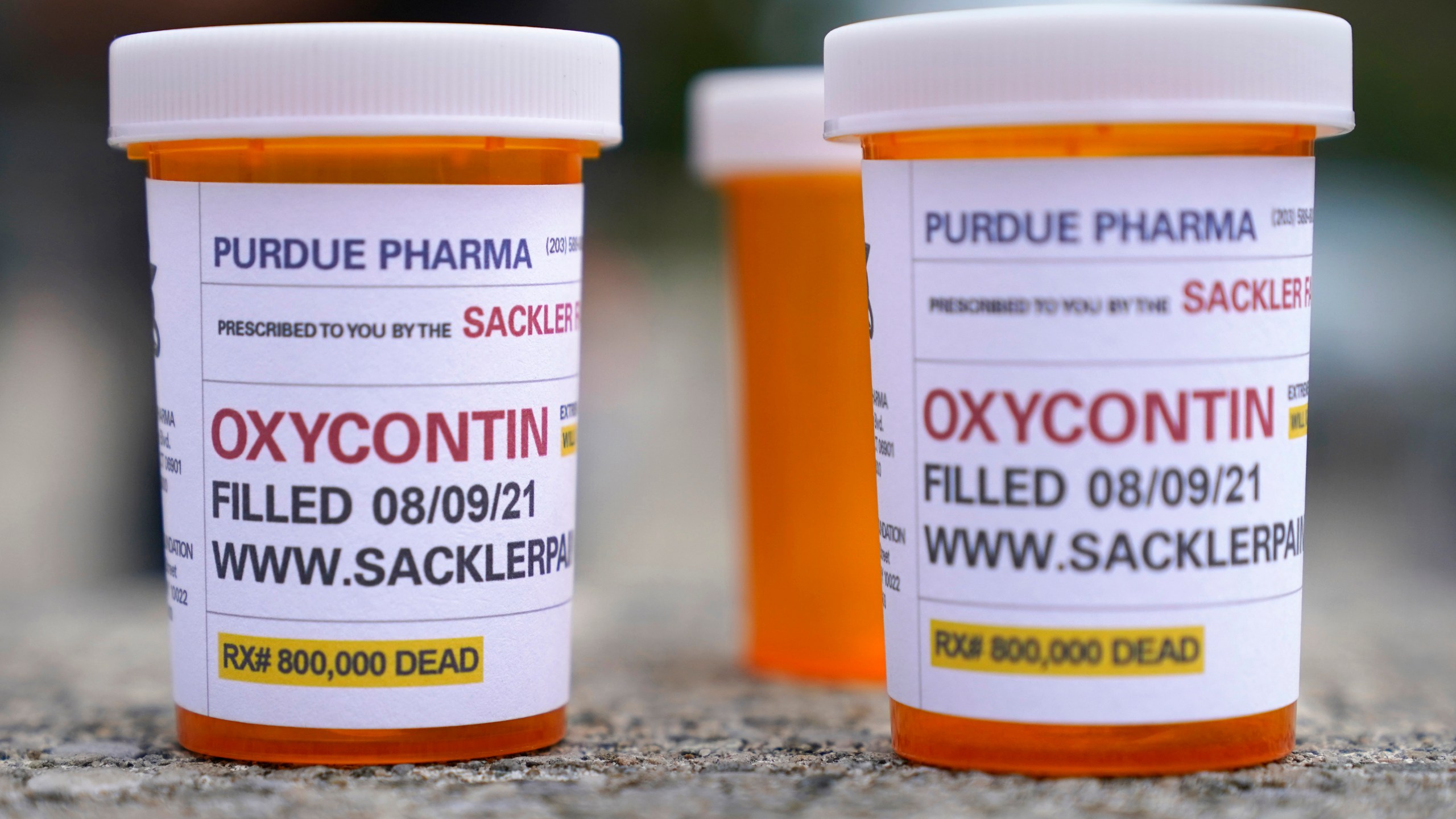 In this Aug. 9, 2021, file photo, fake pill bottles with messages about OxyContin maker Purdue Pharma are displayed during a protest outside the courthouse where the bankruptcy of the company is taking place in White Plains, N.Y. (Seth Wenig/Associated Press)