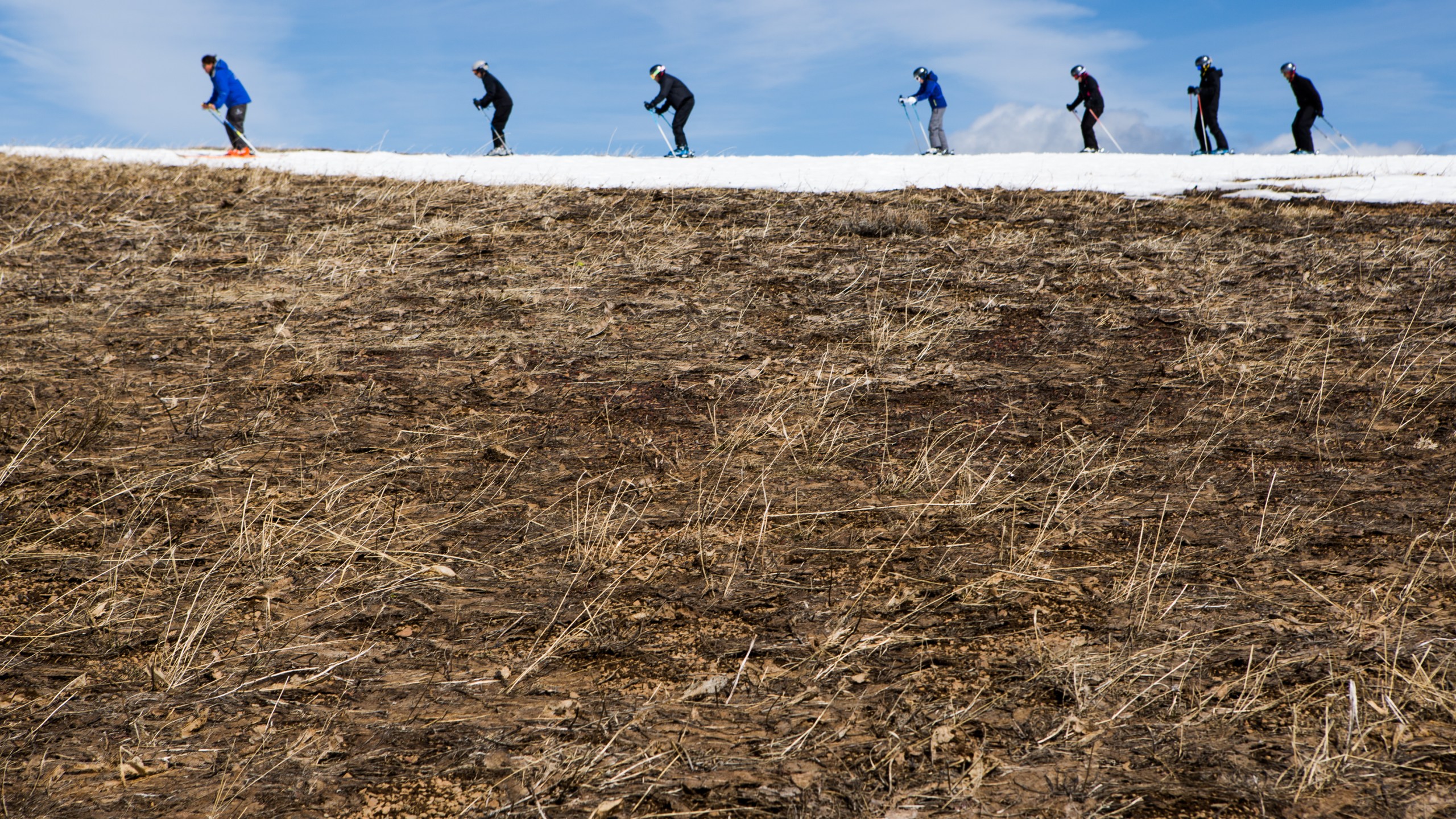 Skiers thread their way through patches of dry ground on March 21, 2015 in Olympic Valley, California. Many Tahoe-area ski resorts closed due to low snowfall in 2015, and in 2021, dry conditions again plagued the resorts. (Max Whittaker/Getty Images)