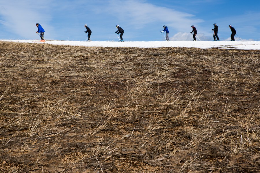 Skiers thread their way through patches of dry ground on March 21, 2015 in Olympic Valley, California. Many Tahoe-area ski resorts closed due to low snowfall in 2015, and in 2021, dry conditions again plagued the resorts. (Max Whittaker/Getty Images)