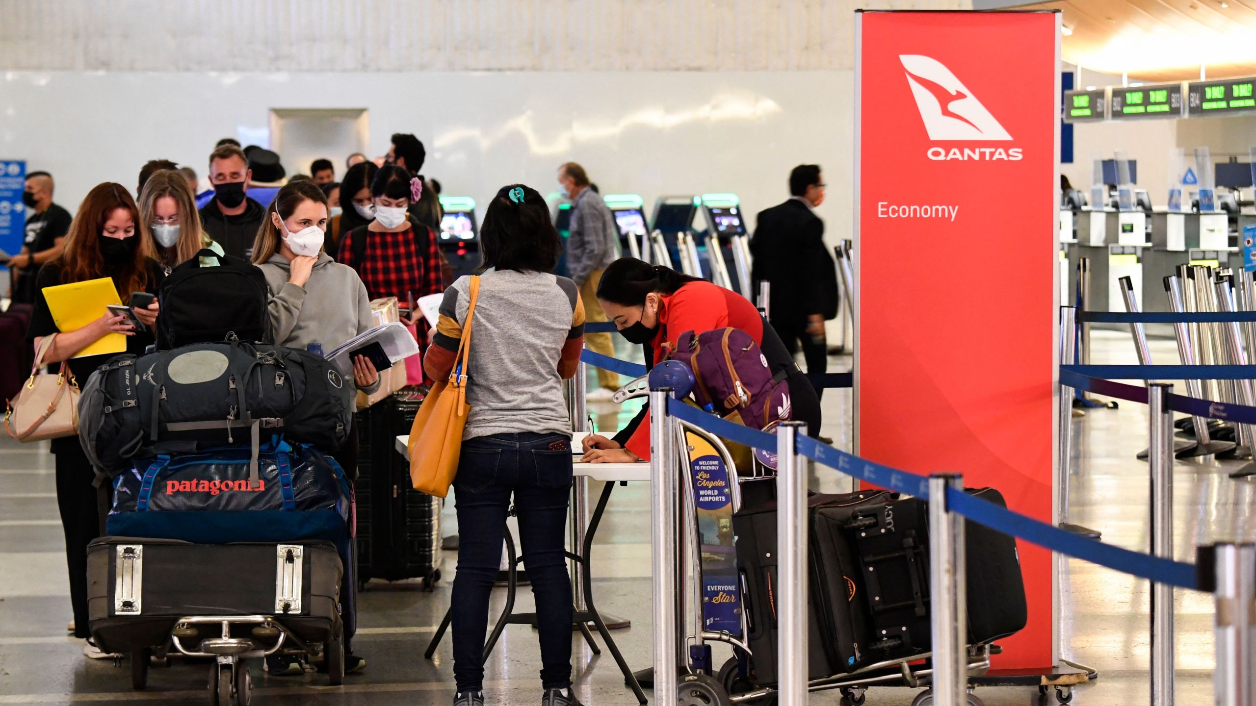 Travelers wait in line verify COVID-19 vaccination status as they check-in for a flight to Sydney, Australia on Qantas Airways Ltd. inside the Tom Bradley International Terminal at LAX on Nov. 1, 2021. (PATRICK T. FALLON/AFP via Getty Images)