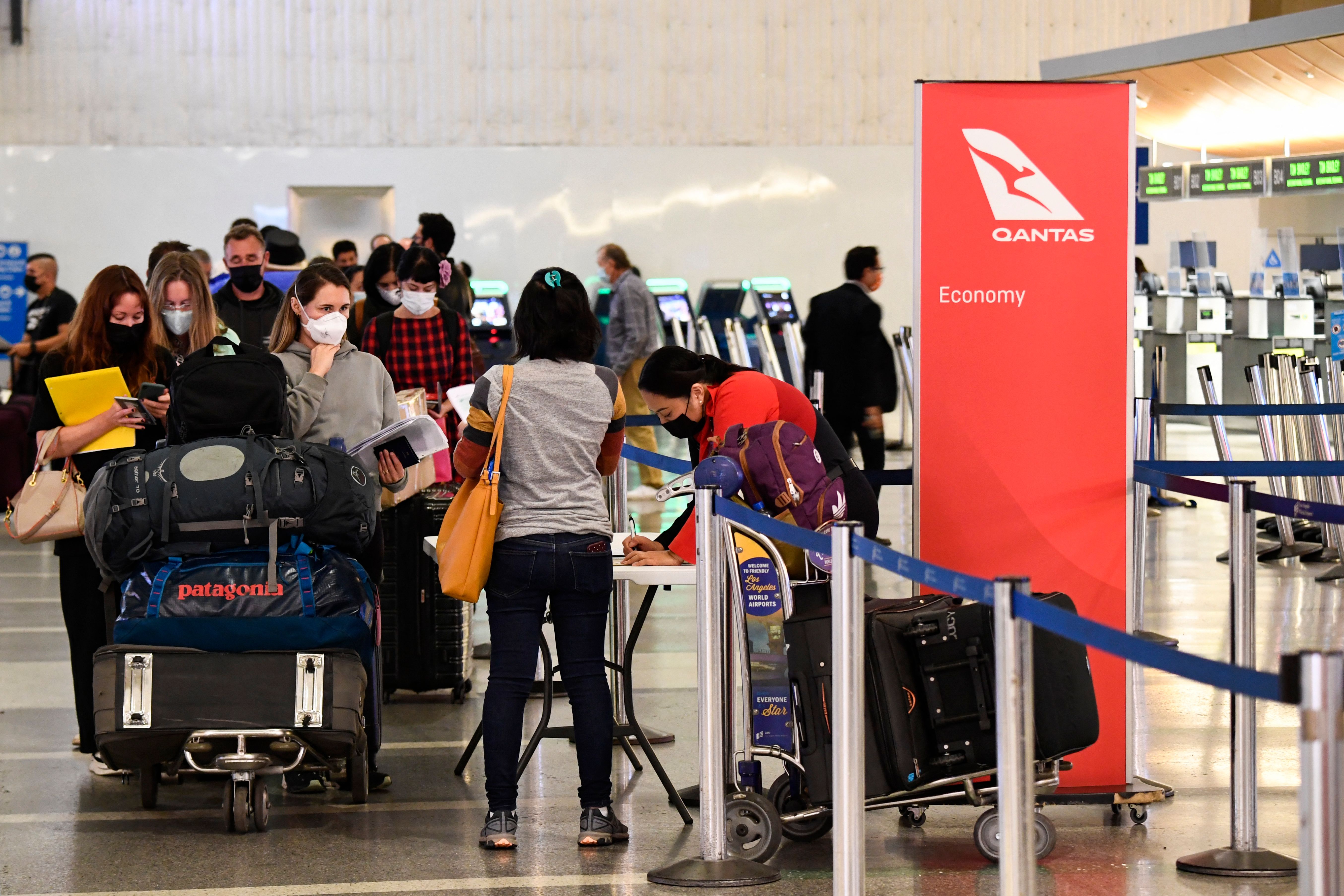 Travelers wait in line verify COVID-19 vaccination status as they check-in for a flight to Sydney, Australia on Qantas Airways Ltd. inside the Tom Bradley International Terminal at LAX on Nov. 1, 2021. (PATRICK T. FALLON/AFP via Getty Images)