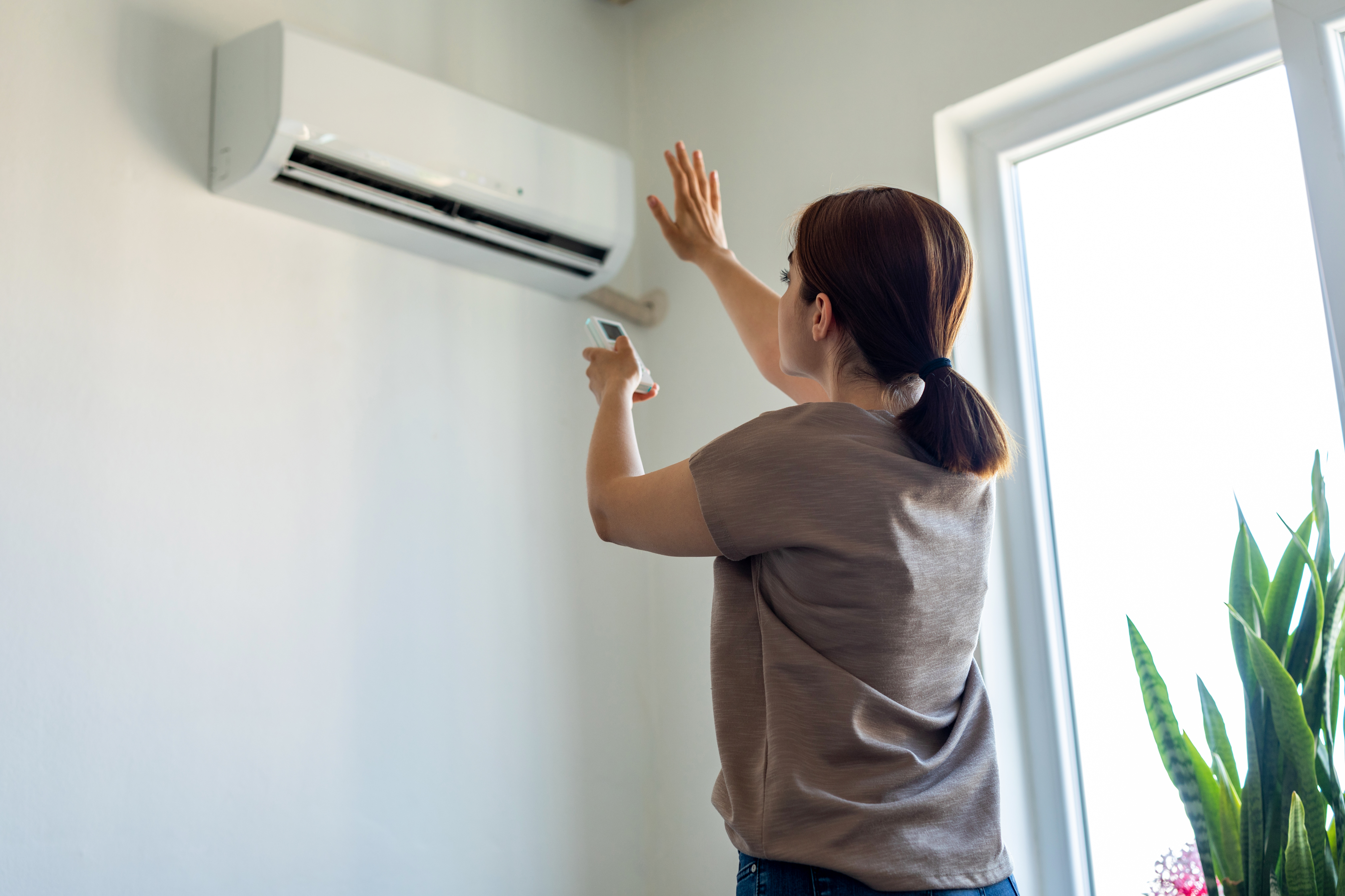 This file photo shows a woman turning on an air conditioner. (Getty Images)