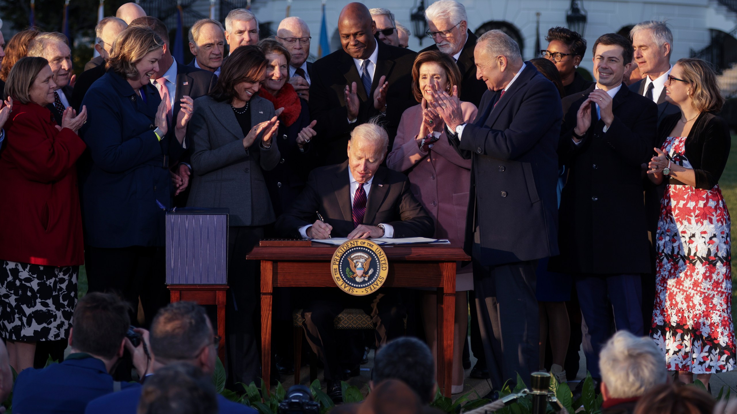 President Joe Biden signs the Infrastructure Investment and Jobs Act as he is surrounded by lawmakers and members of his Cabinet during a ceremony on the South Lawn at the White House on Nov. 15, 2021. (Alex Wong/Getty Images)