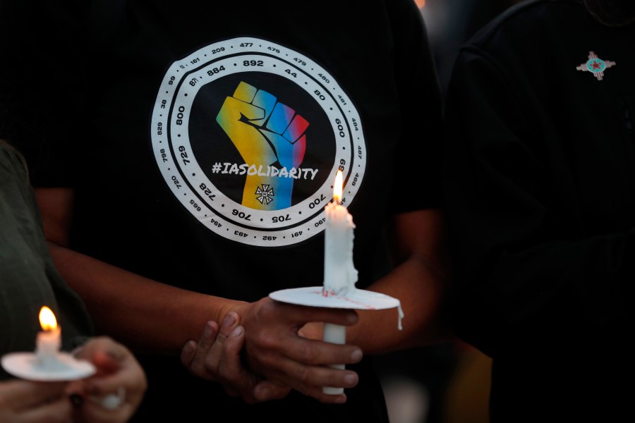 Movie industry worker Hailey Josselyn, wearing a t-shirt of the International Alliance of Theatrical Stage Employees (IATSA), holds a candle during a vigil to honor cinematographer Halyna Hutchins in Albuquerque, N.M., on Oct. 23, 2021. Hutchins was fatally shot on Thursday, Oct. 21, after an assistant director unwittingly handed actor Alec Baldwin a loaded weapon and told him it was safe to use on the set of a Western filmed in Santa Fe, N.M. Members of the IATSA,will vote on a proposed three-year union contract with Hollywood producers. (AP Photo/Andres Leighton, File)