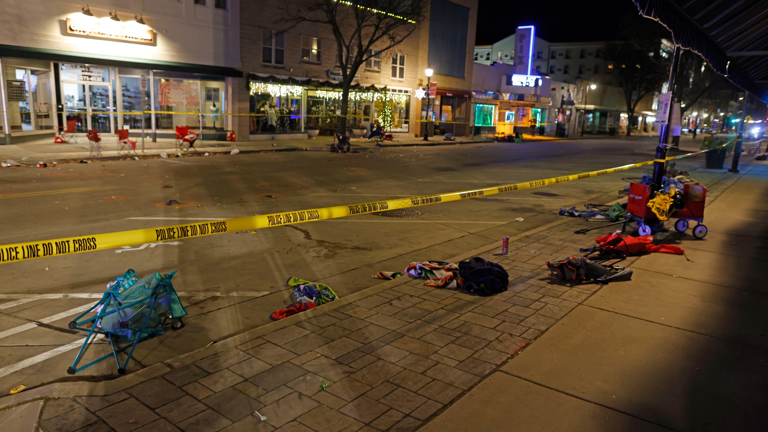 Police tape cordons off a street in Waukesha, Wis., after a vehicle plowed into a Christmas parade hitting more than 20 people Sunday, Nov. 21, 2021. (AP Photo/Jeffrey Phelps)