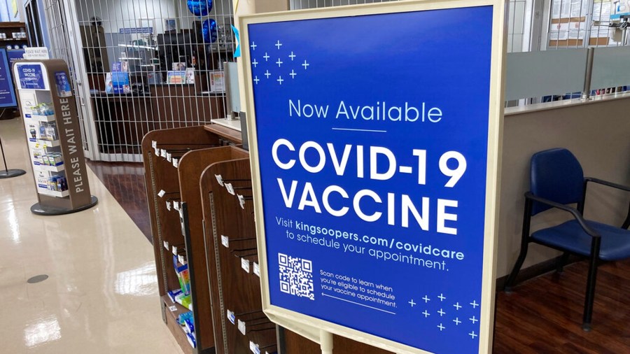 In this Saturday, Oct. 23, 2021, photograph, a sign notifies customers that COVID-19 vaccinations are available at a pharmacy in a grocery store in Monument, Colo. (AP Photo/David Zalubowski)