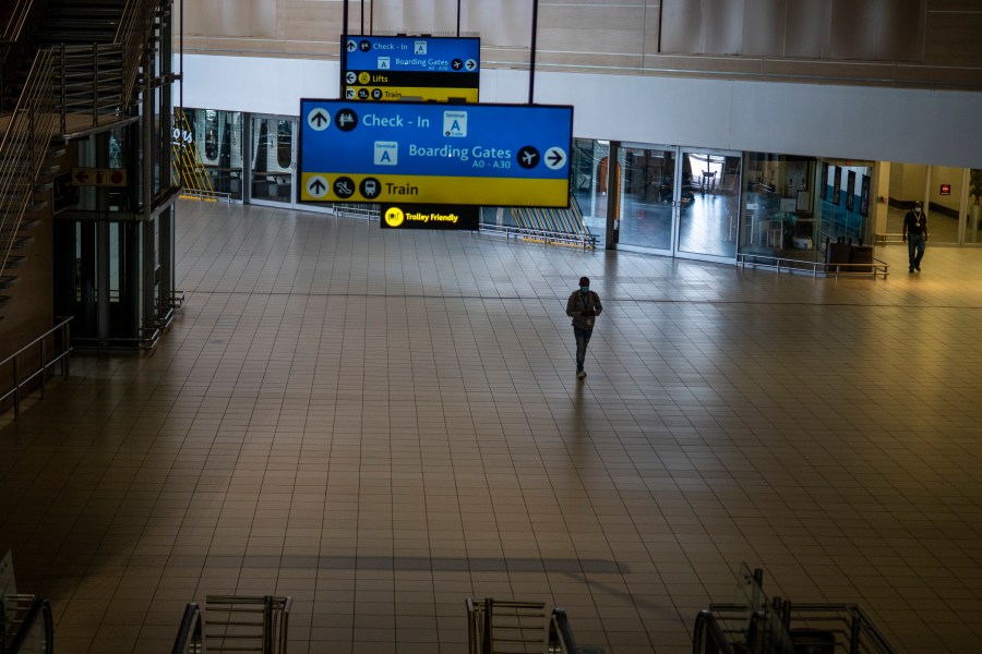 A man walks through a deserted part of Johannesburg's OR Tambo's airport, South Africa, Monday Nov. 29, 2021. As countries shut their doors to foreign tourists or reimpose restrictions because of the new omicron variant of the coronavirus, tourism that was just finding it's footing again could face another major pandemic slowdown amid the uncertainty about the new strain. (AP Photo/Jerome Delay, File)