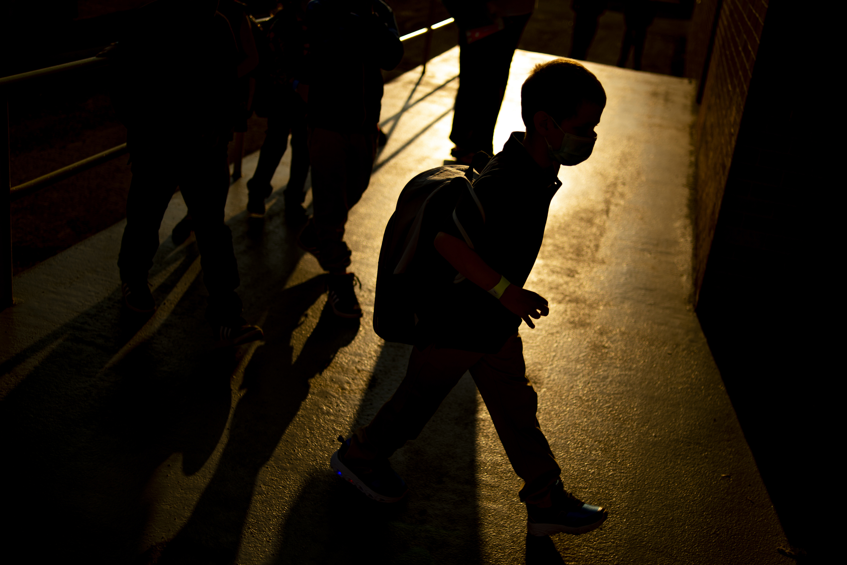 A student arrives as the sun rises during the first day of school on Aug. 4, 2021 at Freeman Elementary School in Flint, Mich. New autism numbers released Dec. 2 suggest more U.S. children are being diagnosed with the developmental condition and at younger ages. (Jake May/The Flint Journal via AP)