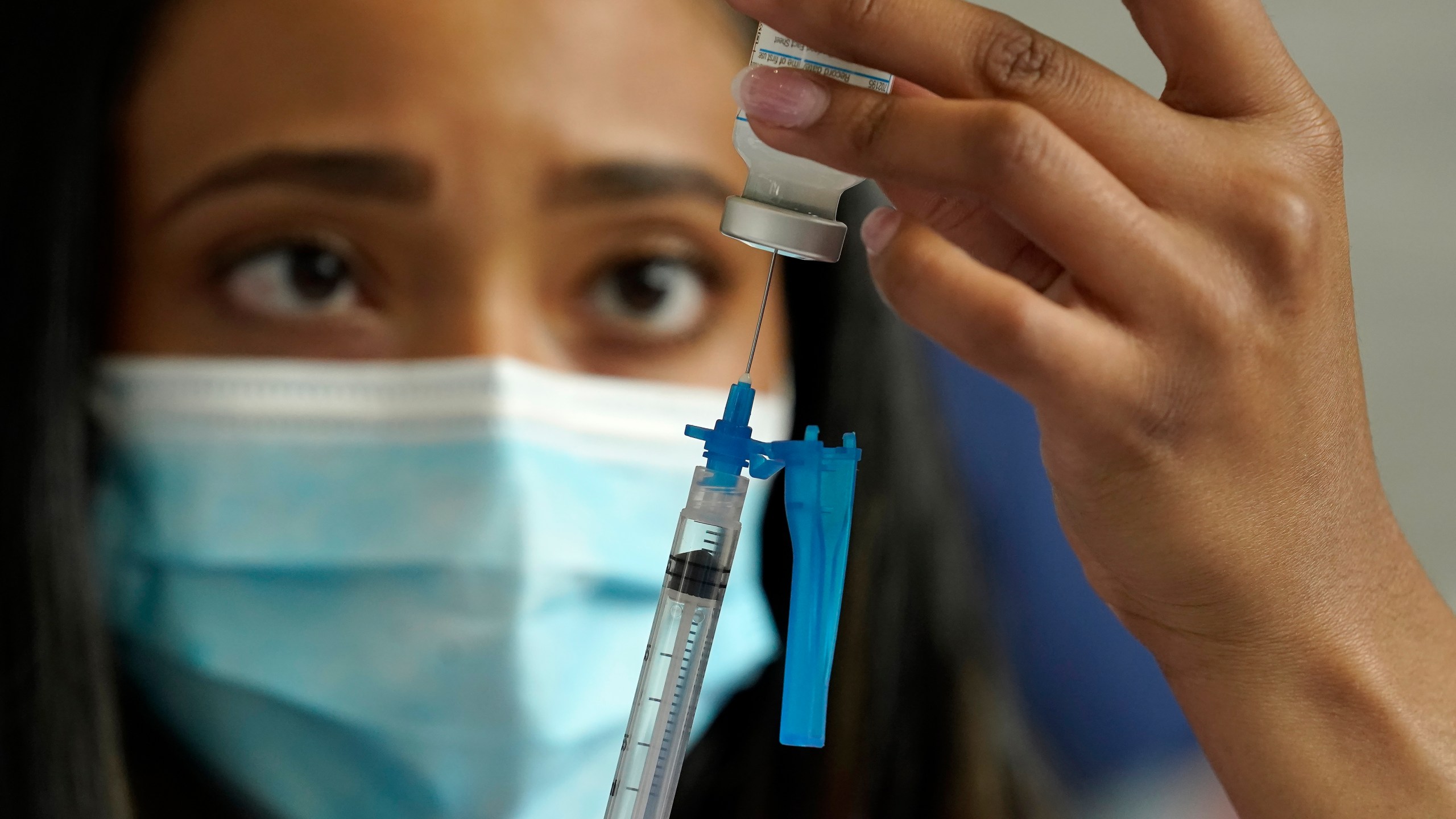 Licensed practical nurse Yokasta Castro, of Warwick, R.I., draws a Moderna COVID-19 vaccine into a syringe at a mass vaccination clinic on May 19, 2021 at Gillette Stadium, in Foxborough, Mass. (Steven Senne/Associated Press)