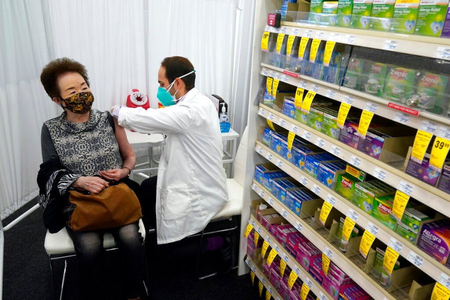 Pharmacist Todd Gharibian, right, administers a dose of the Moderna COVID-19 vaccine to Toshiko Sugiyama, left, at a CVS Pharmacy branch on March 1, 2021, in Los Angeles. (AP Photo/Marcio Jose Sanchez, File)