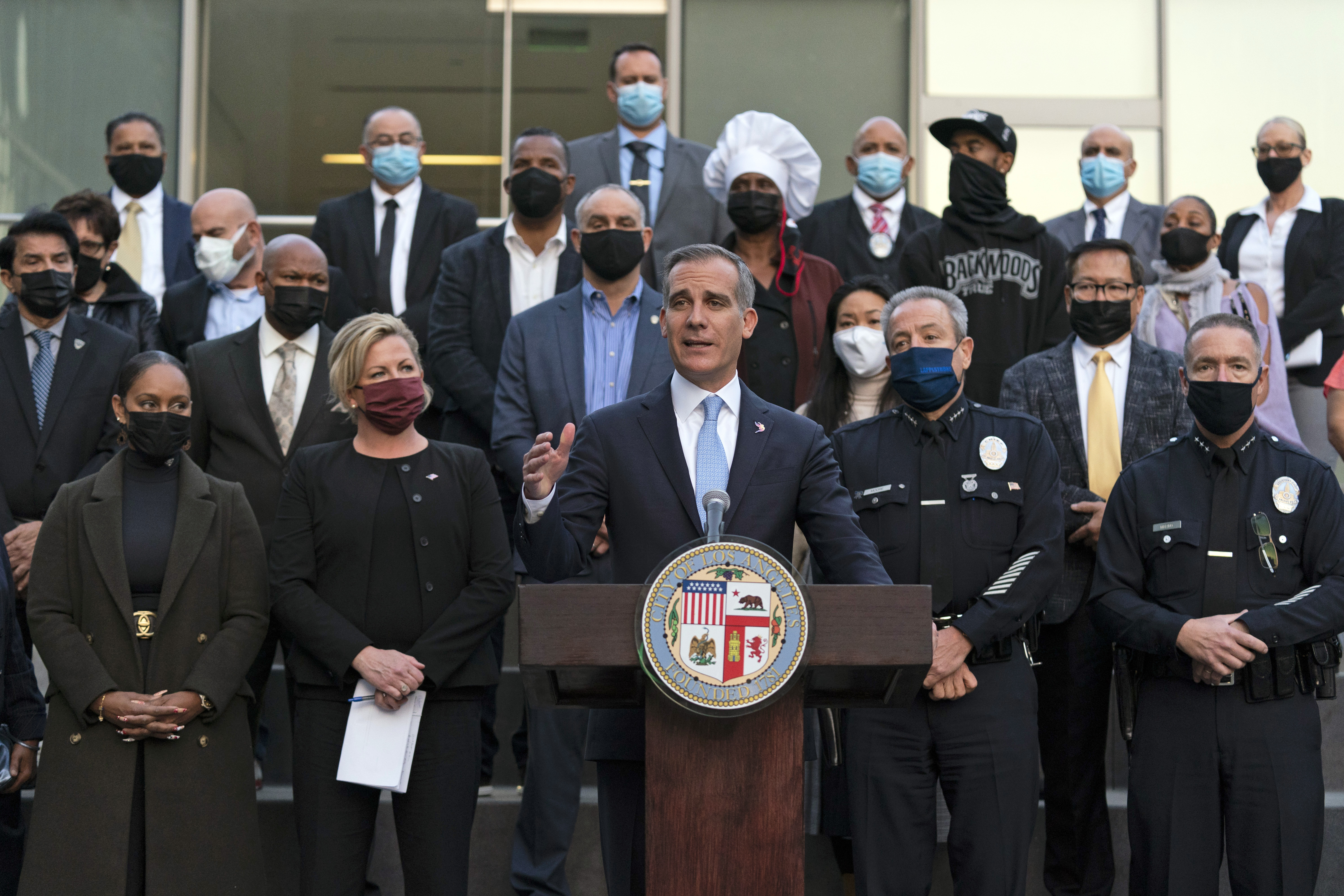 Joined by business owners and community leaders, Los Angeles Mayor Eric Garcetti, center, speaks during a news conference outside the Los Angeles Police Headquarters in Los Angeles, Thursday, Dec. 2, 2021. Authorities in Los Angeles on Thursday announced arrests in recent smash-and-grab thefts at stores, part of a rash of organized retail crime in California. (AP Photo/Jae C. Hong)