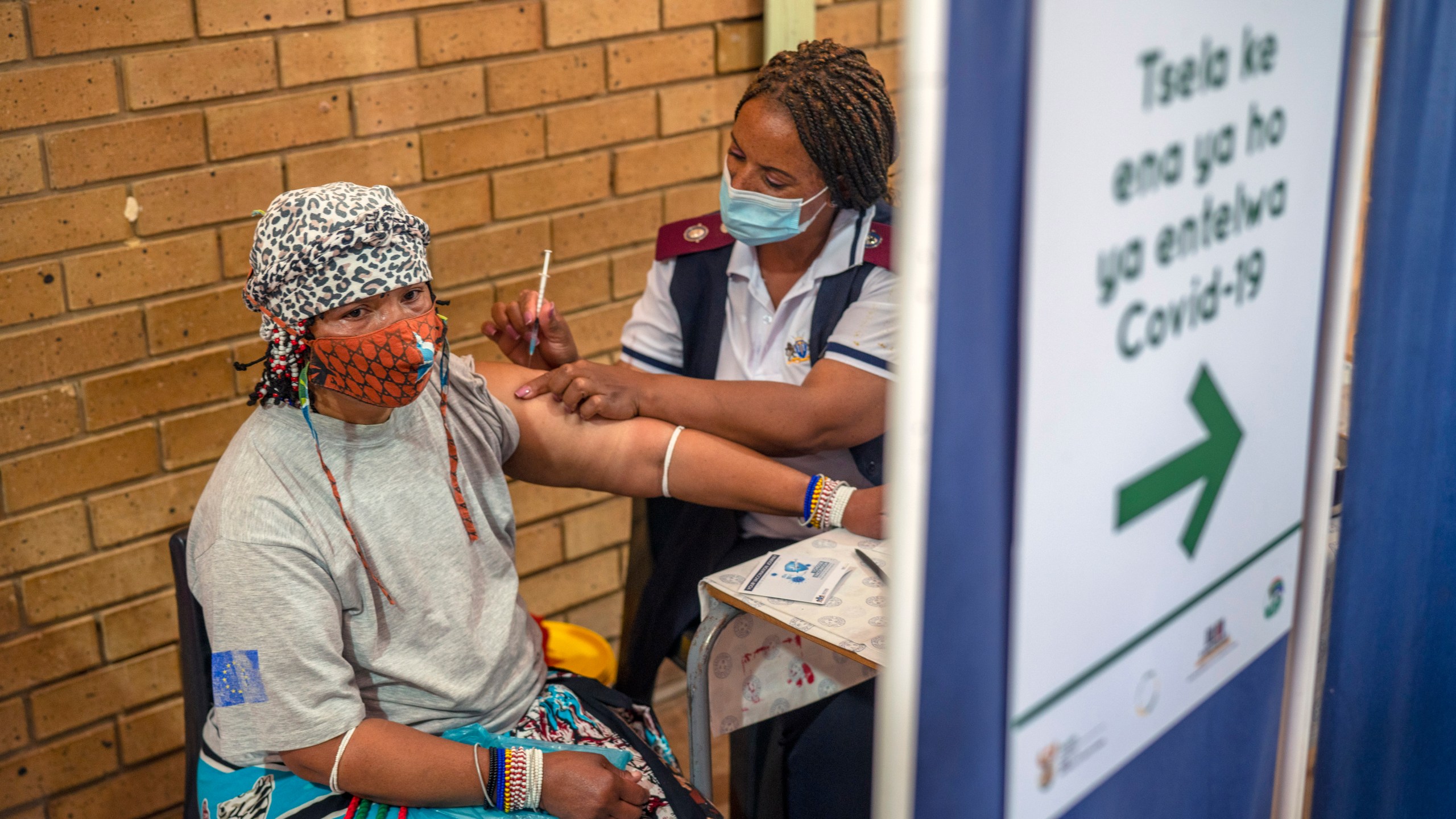 An Orange Farm, South Africa, resident receives her jab against COVID-19 Friday Dec. 3, 2021 at the Orange Farm multipurpose center. South Africa has accelerated its vaccination campaign a week after the discovery of the omicron variant of the coronavirus. (AP Photo/Jerome Delay)