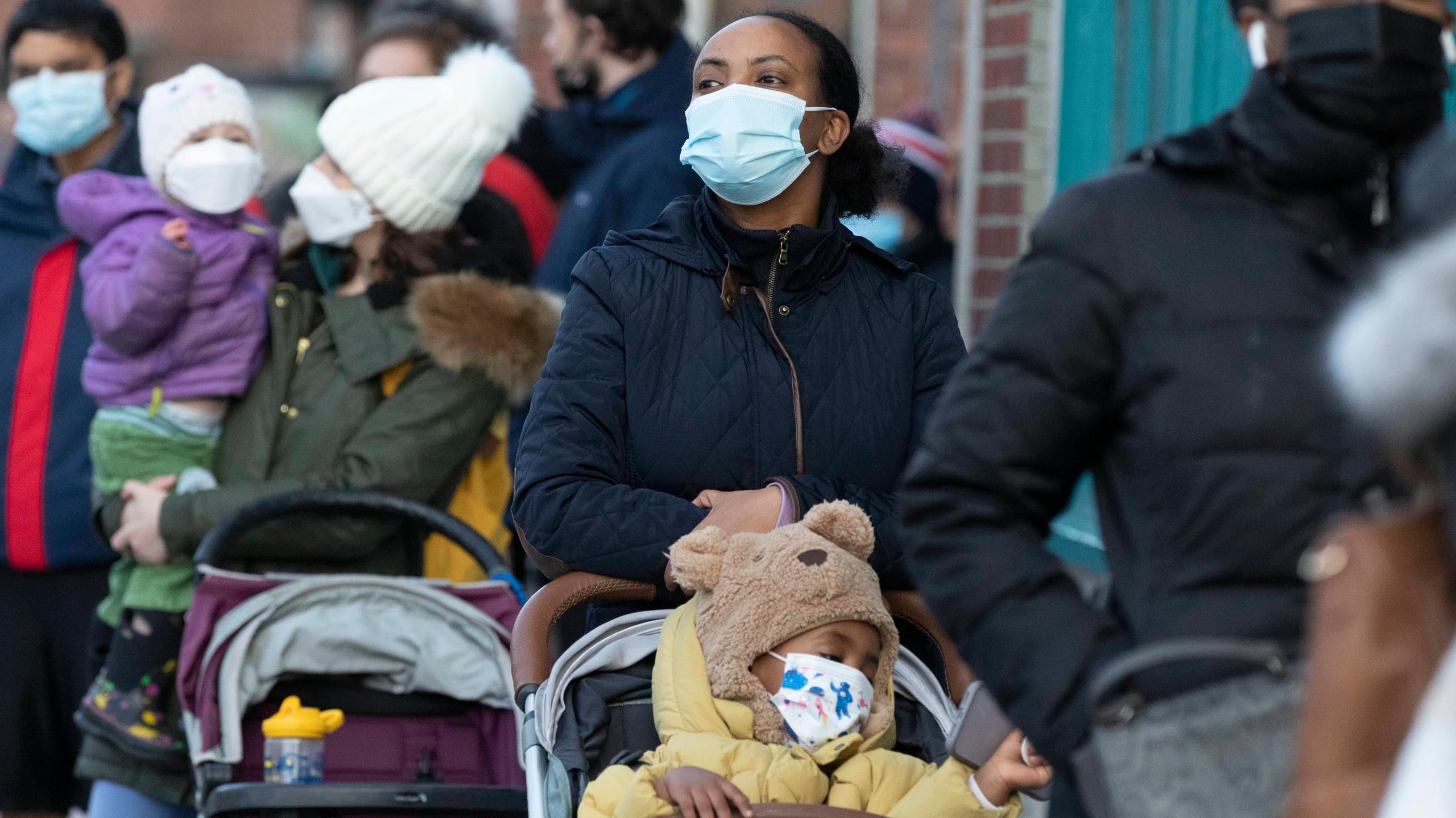 Makda Yesuf, center, and her son Jaden wait in line at a COVID-19 walk-in testing site on Dec. 5, 2021, in Cambridge, Mass. (AP Photo/Michael Dwyer, File)