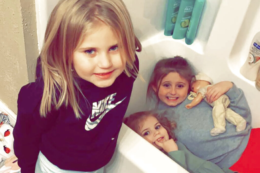 In this Dec. 10, 2021, photo provided by Sandra Hooker, from left, Avalinn Rackley, 7, Alanna Rackley, 3, and Annistyn Rackley, 9, pose for a picture in a bathroom in their home near Caruthersville, Missouri. (Meghan Rackley/Courtesy of Sandra Hooker via AP)