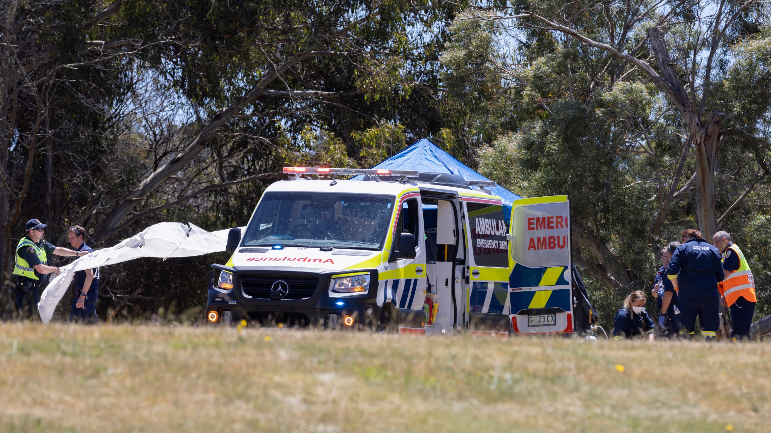 Emergency services personnel work the scene of a deadly incident involved with a bouncy castle at the Hillcrest Primary School in Devonport, Tasmania, Thursday, Dec. 16, 2021. Multiple children have died and others are in critical condition after falling from a bouncy castle that was lifted 10 meters (33 feet) into the air by a gust of wind at a junior school on the island state of Tasmania on Thursday. (Grant Wells/AAP Image via AP)