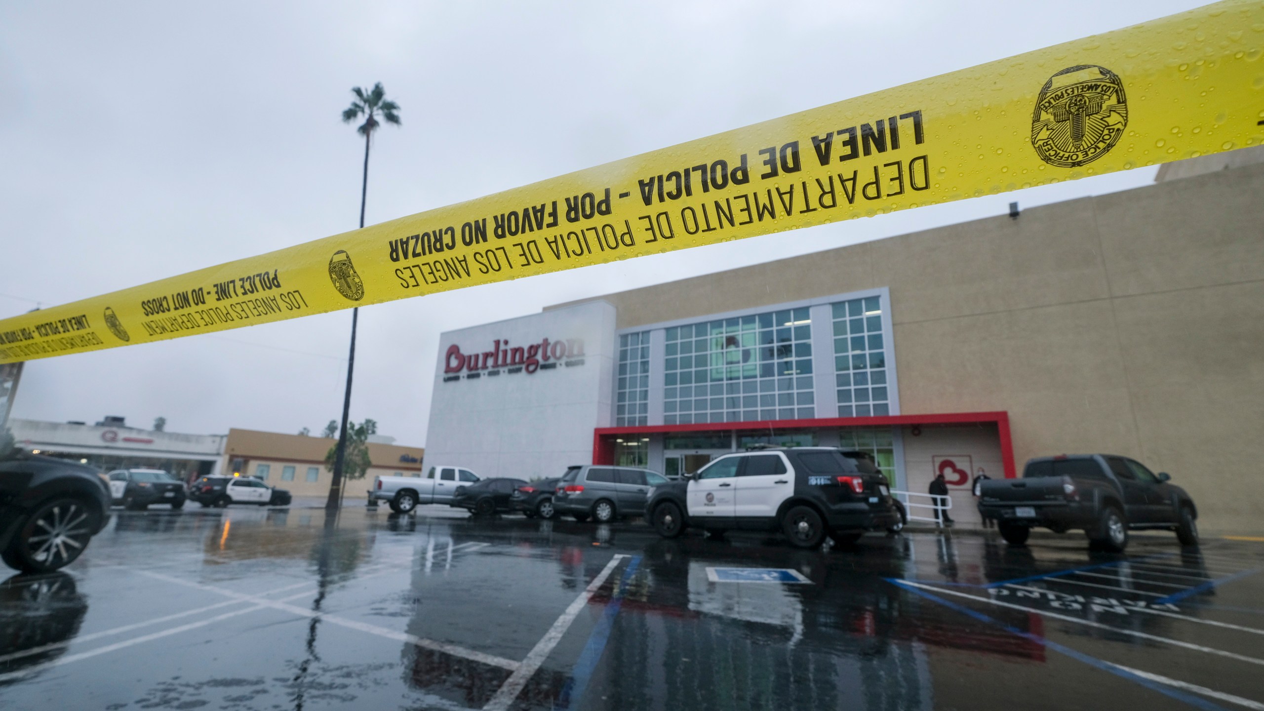 A police yellow tape is seen at the scene where two people were struck by gunfire in a shooting at a Burlington store — part of a chain formerly known as Burlington Coat Factory in North Hollywood, Calif., Thursday, Dec. 23, 2021. (AP Photo/Ringo H.W. Chiu)