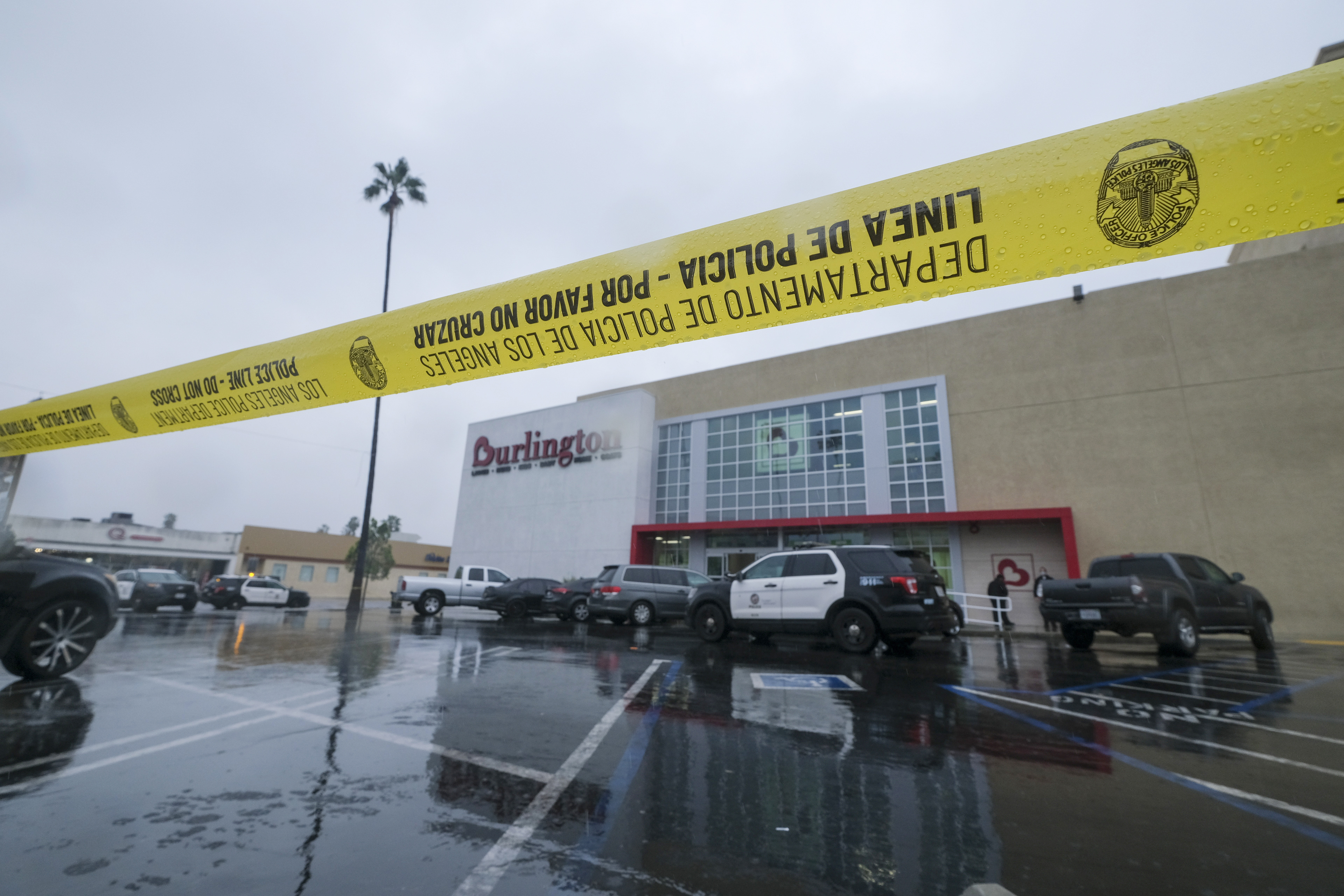 A police yellow tape is seen at the scene where two people were struck by gunfire in a shooting at a Burlington store — part of a chain formerly known as Burlington Coat Factory in North Hollywood, Calif., Thursday, Dec. 23, 2021. (AP Photo/Ringo H.W. Chiu)