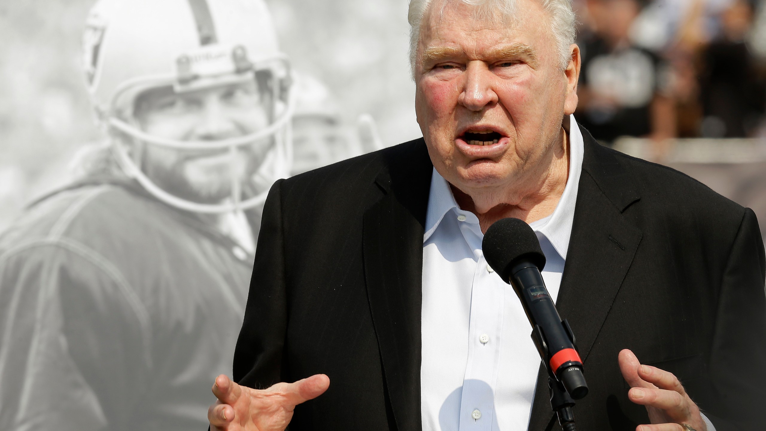 Former Oakland Raiders head coach John Madden speaks about former quarterback Ken Stabler, pictured at rear, at a ceremony honoring Stabler during halftime of an NFL football game between the Raiders and the Cincinnati Bengals in Oakland, Calif., on Sept. 13, 2015. 'All Madden' documentary a labor of love for Fox Sports. Many gamers will be receiving the latest edition of the “Madden” video game for the holidays. On Saturday, Dec. 25, 2021, some will even find out for the first time that the name behind the popular franchise was a successful coach and broadcaster. (AP Photo/Ben Margot, File)