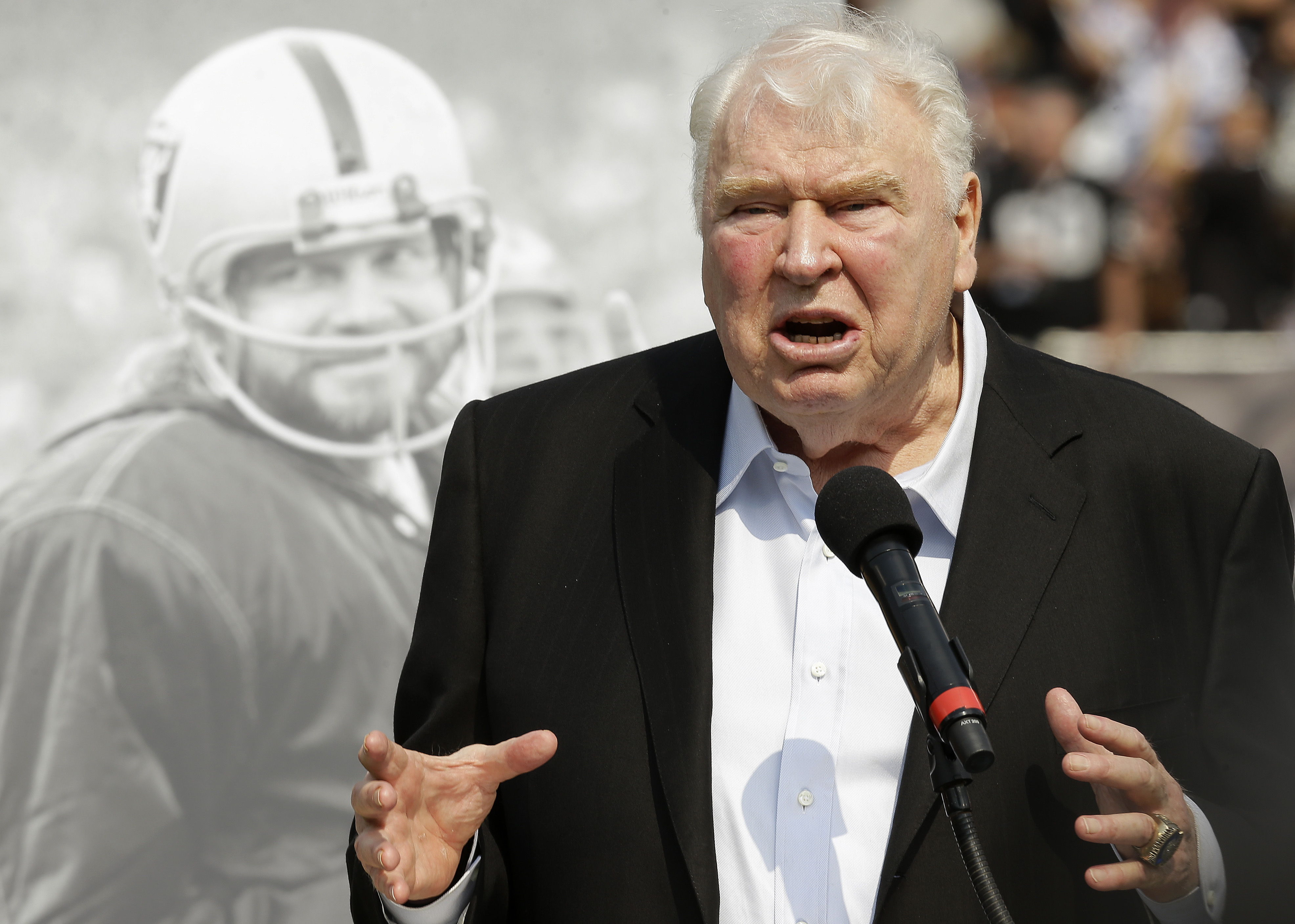 Former Oakland Raiders head coach John Madden speaks about former quarterback Ken Stabler, pictured at rear, at a ceremony honoring Stabler during halftime of an NFL football game between the Raiders and the Cincinnati Bengals in Oakland, Calif., on Sept. 13, 2015. 'All Madden' documentary a labor of love for Fox Sports. Many gamers will be receiving the latest edition of the “Madden” video game for the holidays. On Saturday, Dec. 25, 2021, some will even find out for the first time that the name behind the popular franchise was a successful coach and broadcaster. (AP Photo/Ben Margot, File)