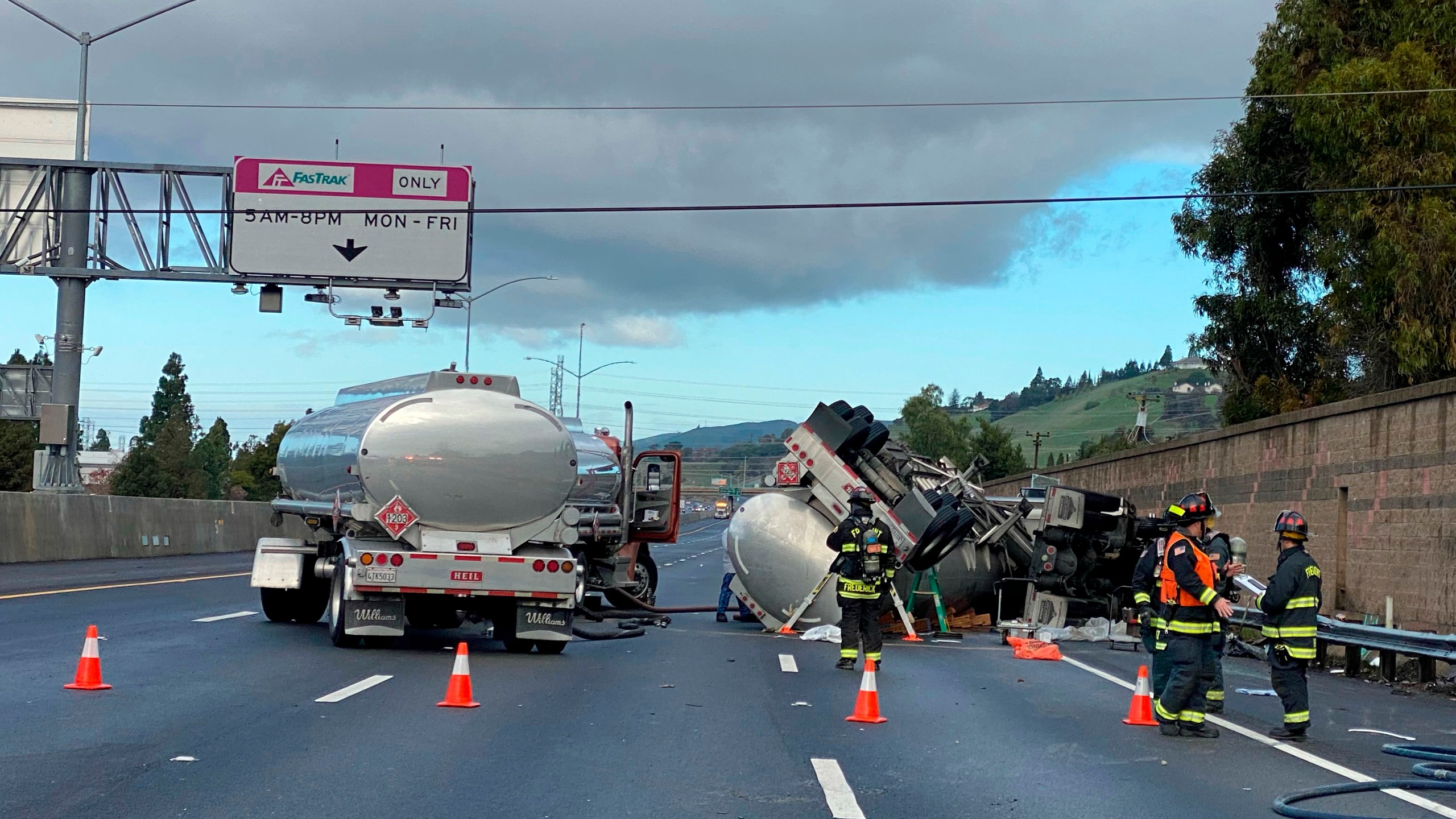 In this photo provided by the Fremont Fire Department, emergency personnel stage at the scene of a fuel tanker accident on Interstate 680, Friday, Dec. 24, 2021, in Fremont, Calif. About 100 homes have been evacuated in the San Francisco Bay Area after a fuel tanker overturned and leaked gasoline. (Aisha Knowles/Fremont Fire Department via AP)