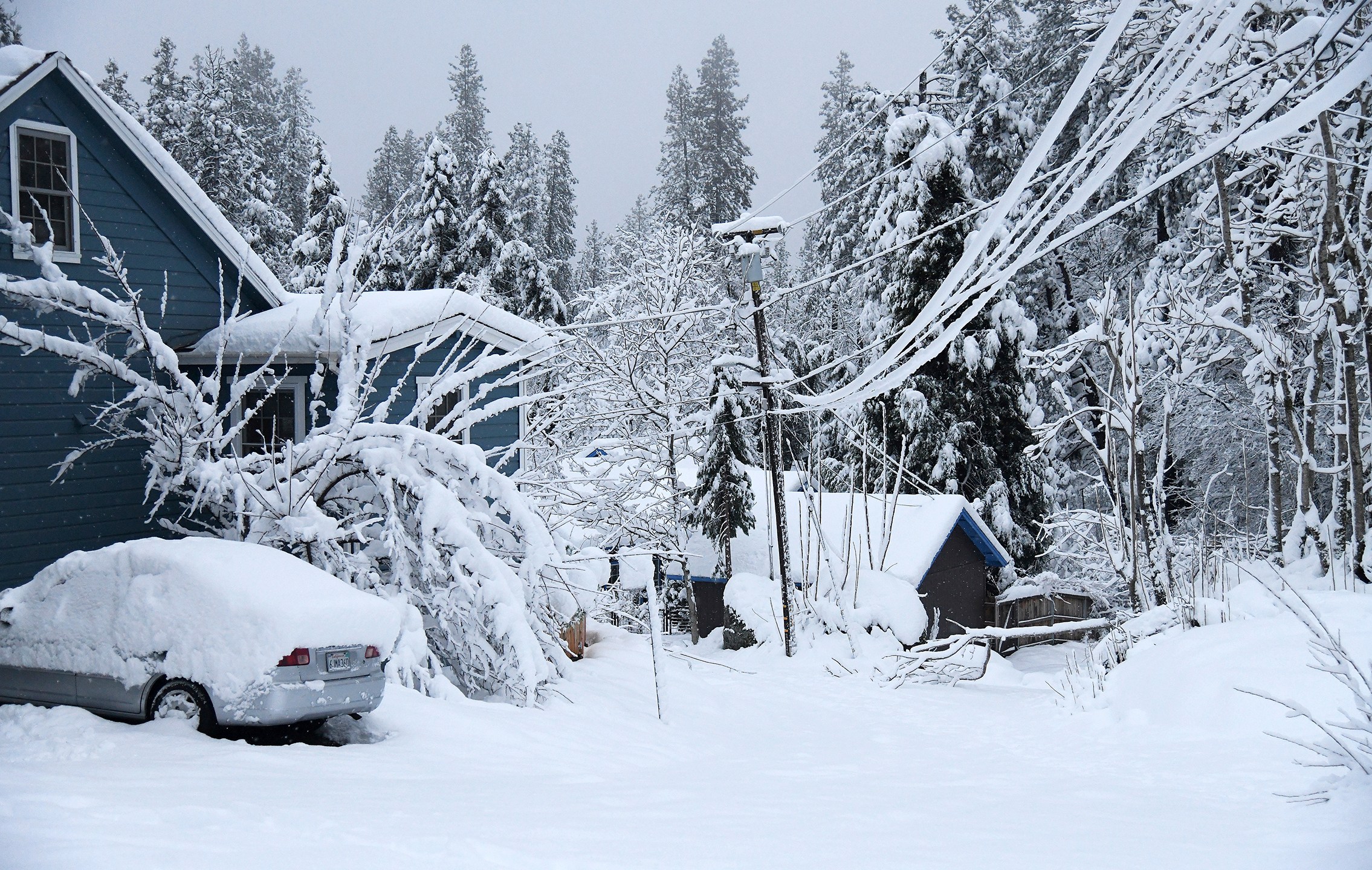 Spring Street in Nevada City, calif., was socked in with snow and downed tree limbs, on Monday, Dec. 27, 2021. (Elias Funez/The Union via AP)